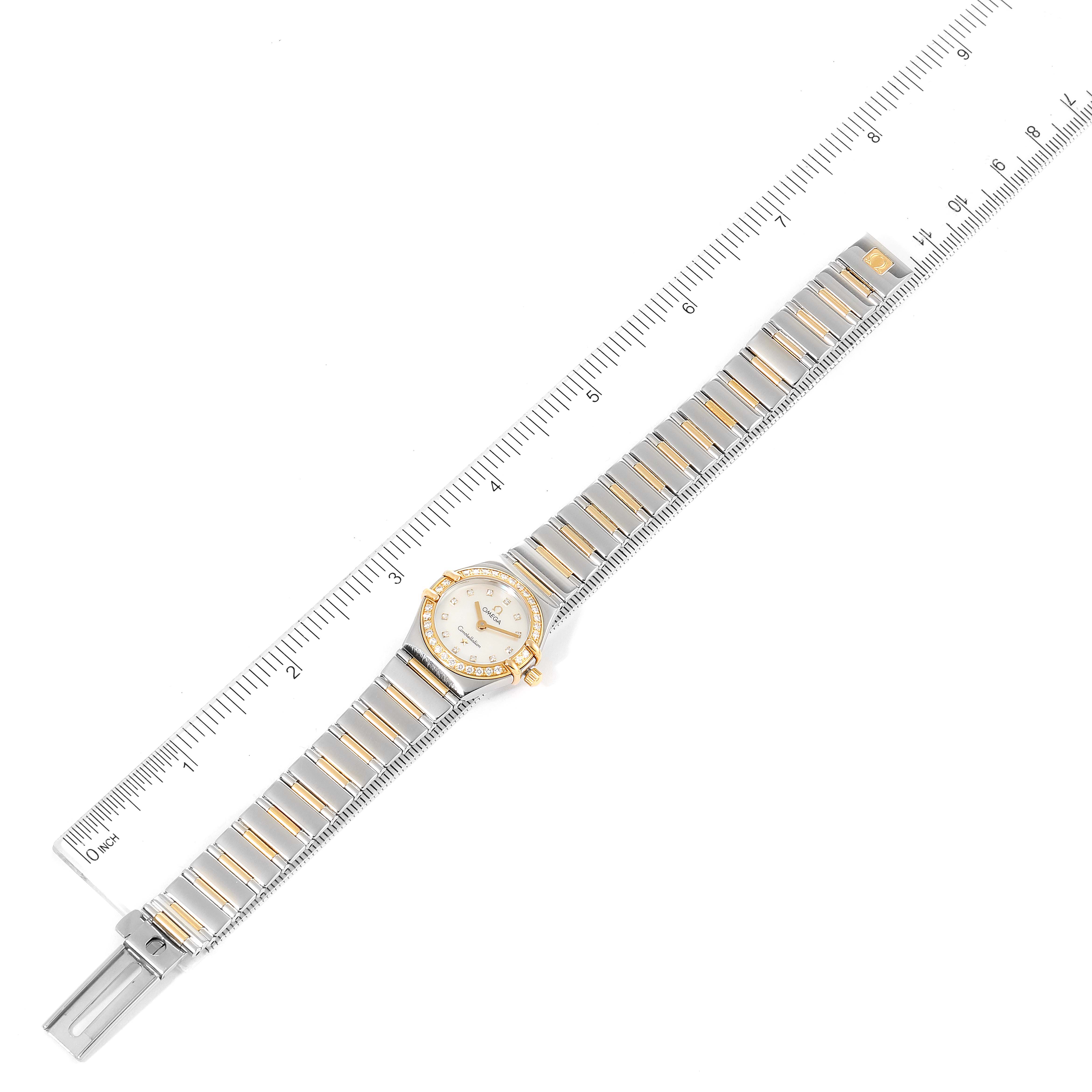 The Omega 1365.75.00 Women's Steel and Gold (two tone) Mother of Pearl Dial 1365.75.00 Women's Steel and Gold (two tone) Mother of Pearl Dial Constellation Steel Yellow Gold Diamond Ladies Watch 1365.75.00 is shown laid flat with a ruler for scale in this image.