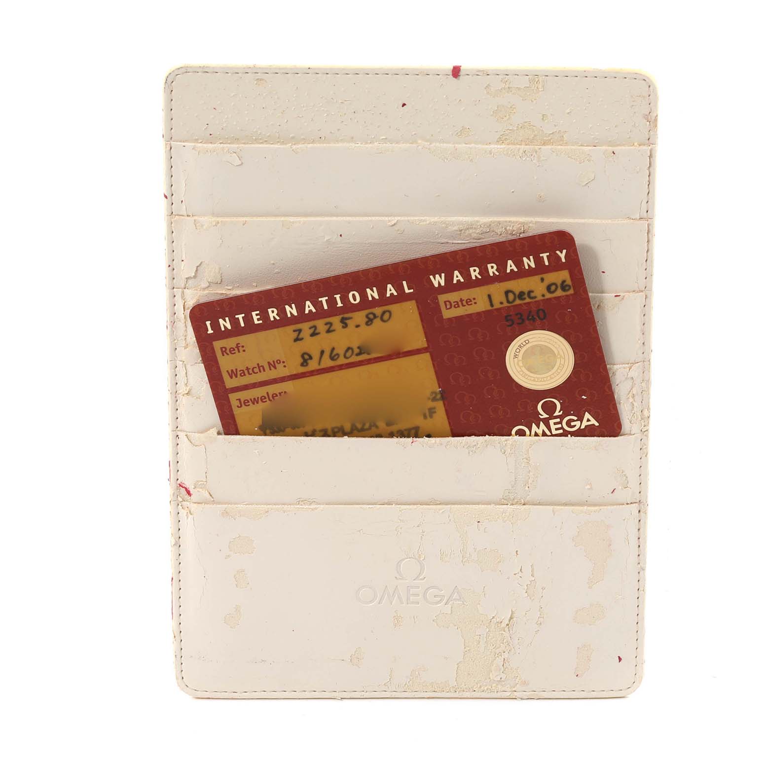 The image shows an Omega warranty card held in a worn white cardholder, indicating it belongs to the Seamaster model.