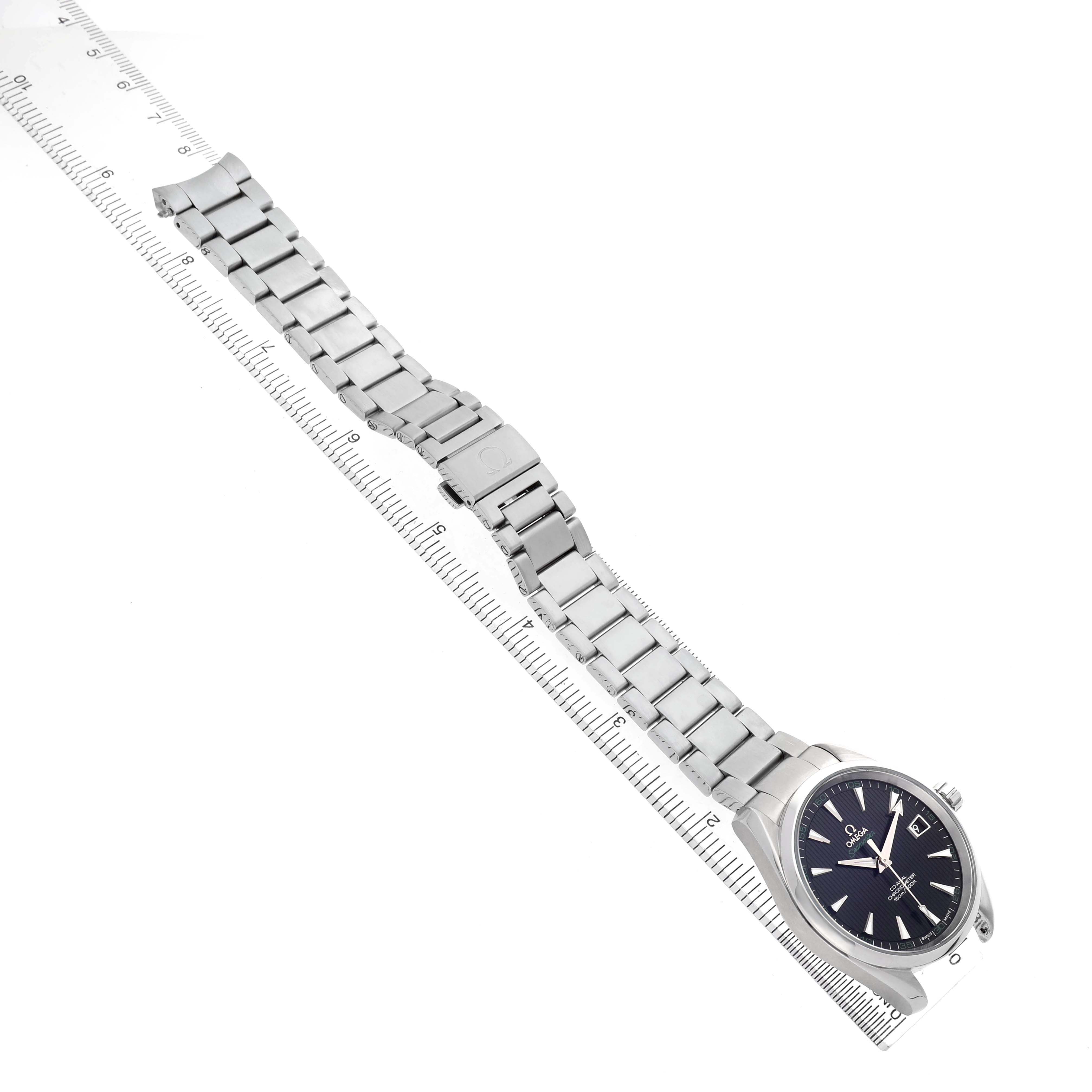 The Omega Aqua Terra 231.10.42.21.01.001 Men's Stainless Steel Black Dial watch is shown at an angled view, highlighting its full metal bracelet and clasp alongside a ruler.
