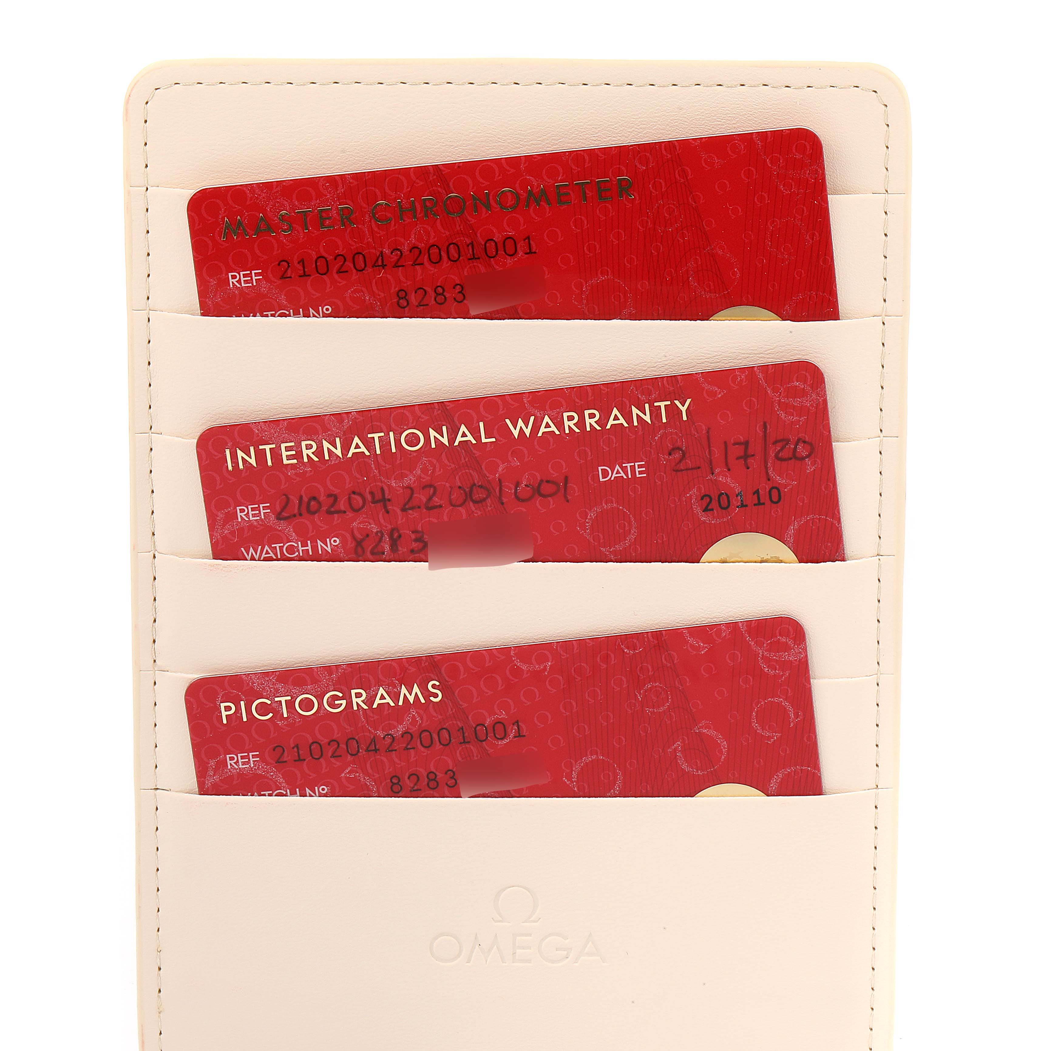 This image shows certification cards and an international warranty card for an Omega Seamaster 210.20.42.20.01.001 Men's Steel and Gold (two tone) Black Dial 210.20.42.20.01.001 Men's Steel and Gold (two tone) Black Dial watch placed in a holder.