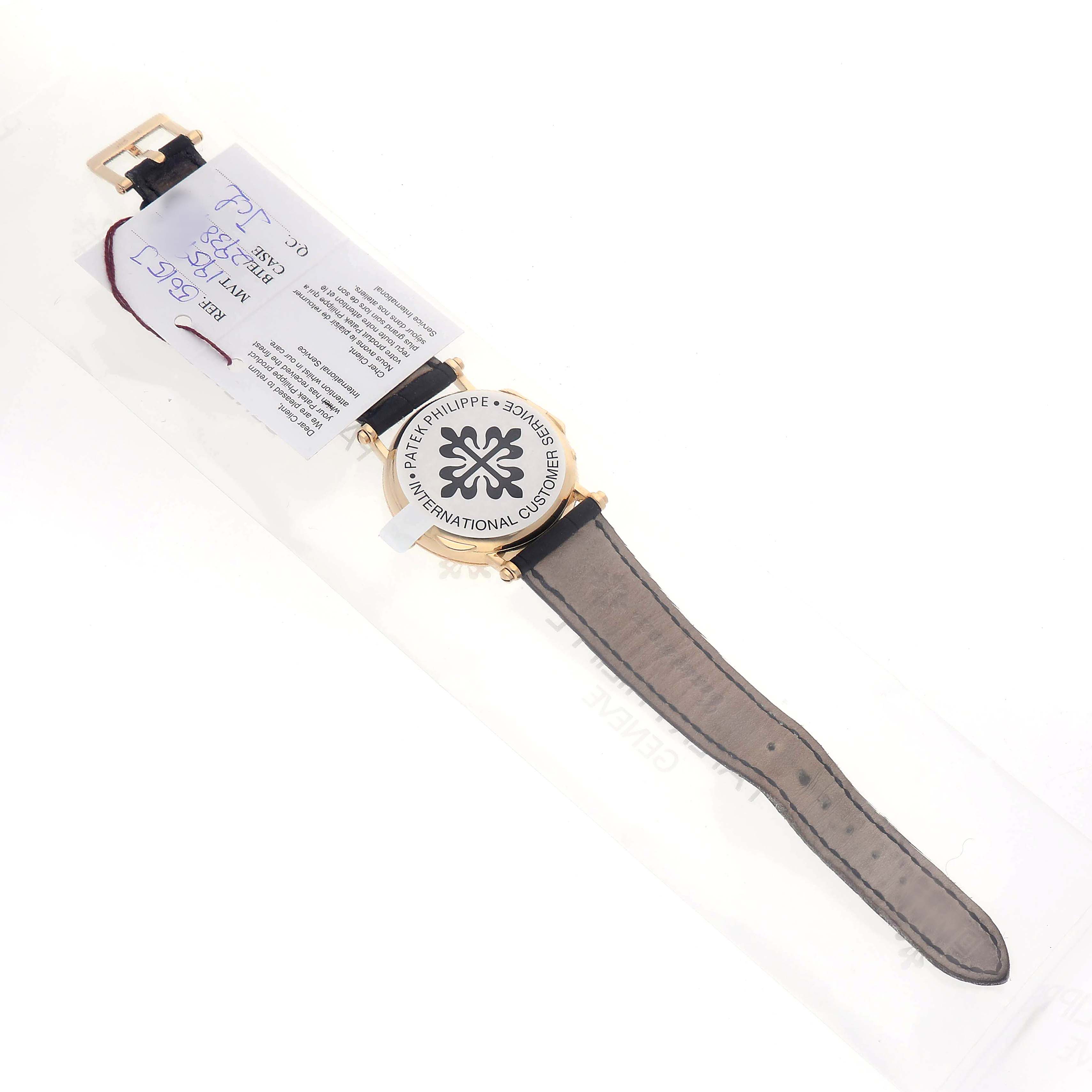 The Patek Philippe Calatrava 5015J-001 Men's Yellow Gold White Dial watch is shown from the back, displaying the caseback, straps, and buckle.
