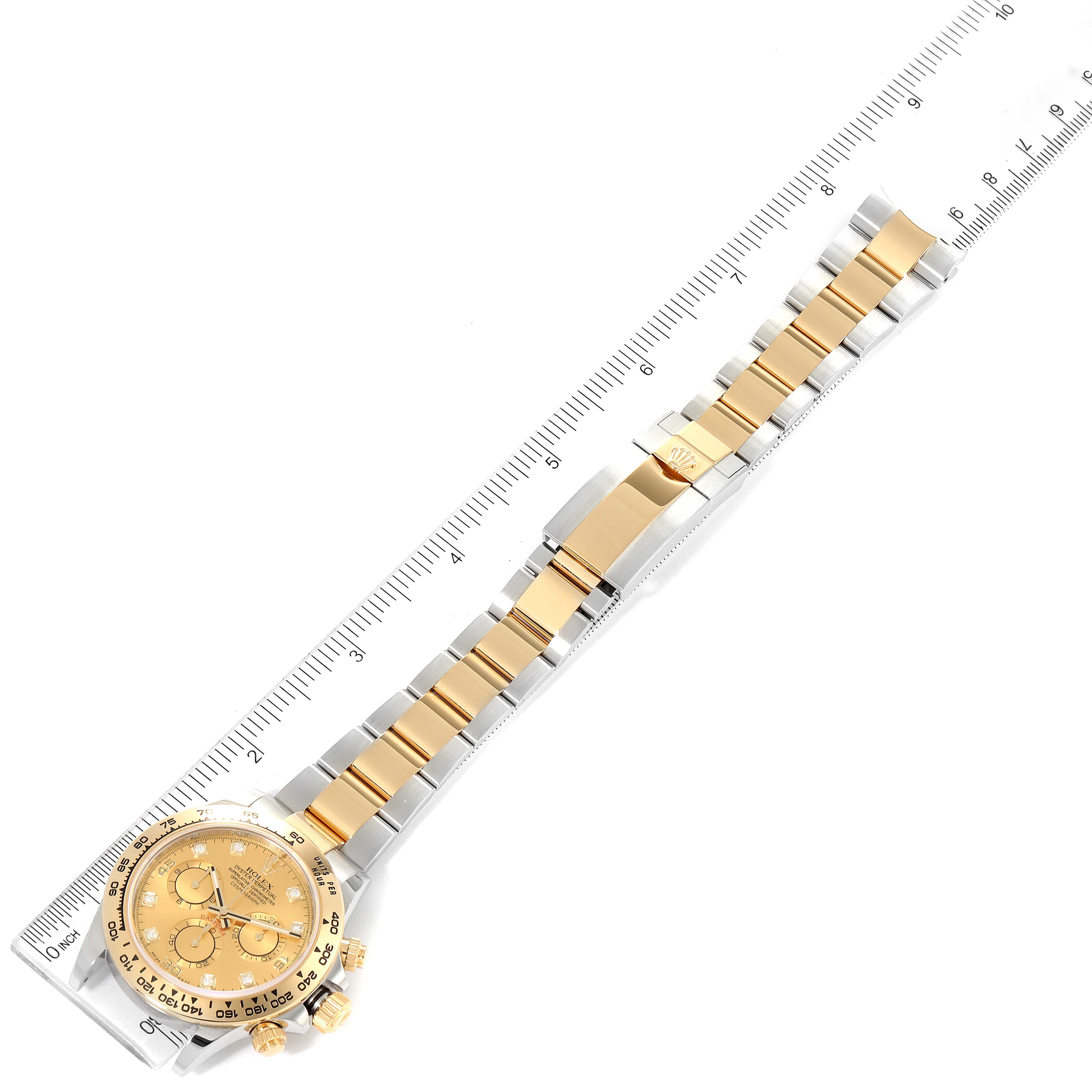 The Rolex Daytona 116503 Men
s Steel and Gold (two tone) Champagne Dial 116503 Men
s Steel and Gold (two tone) Champagne Dial watch is shown from a top-down angle, including the full band and face, next to a measuring ruler.