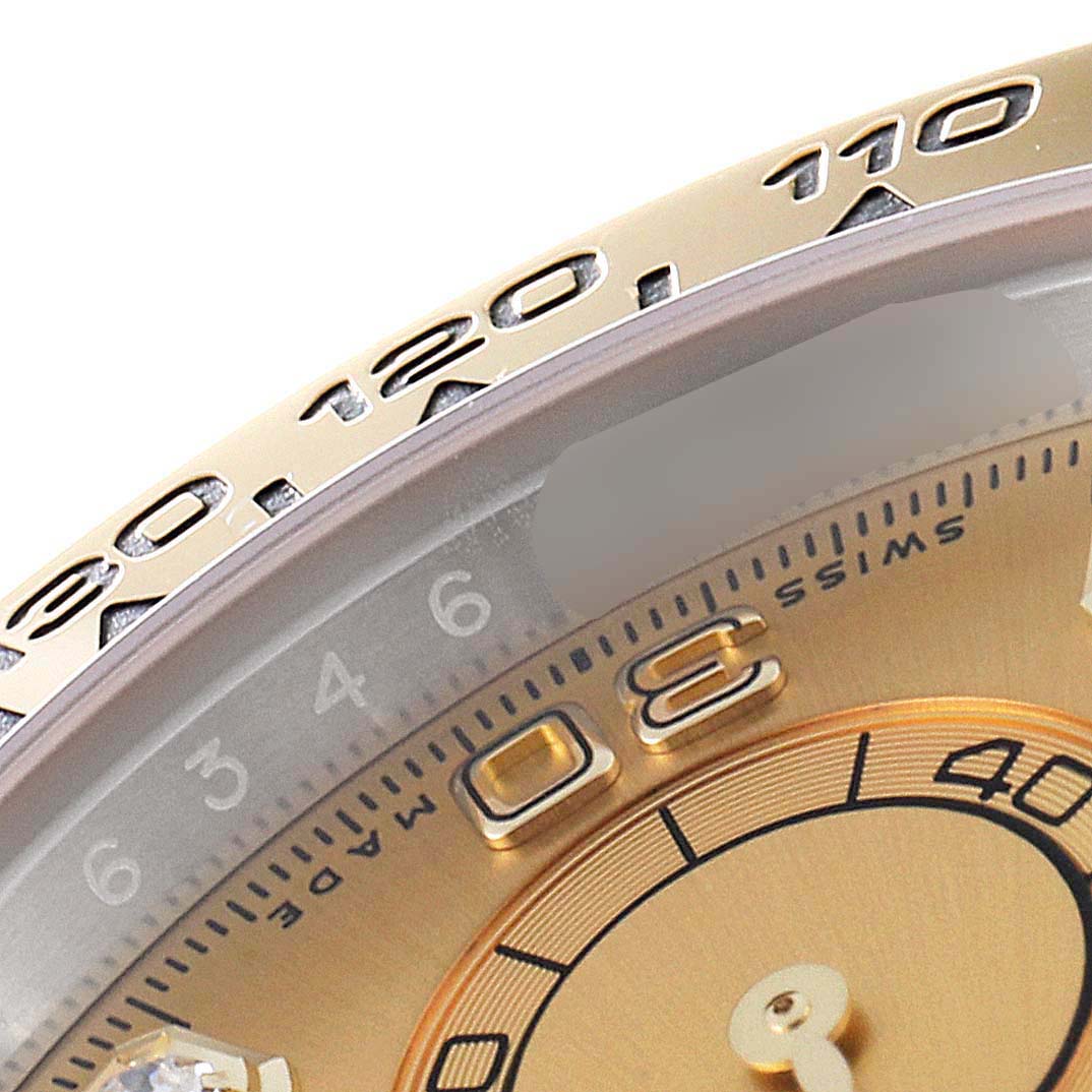 The image shows a close-up of the Rolex Daytona 116503 Men
s Steel and Gold (two tone) Champagne Dial 116503 Men
s Steel and Gold (two tone) Champagne Dial
s bezel, partial dial, and part of the numeral markers.