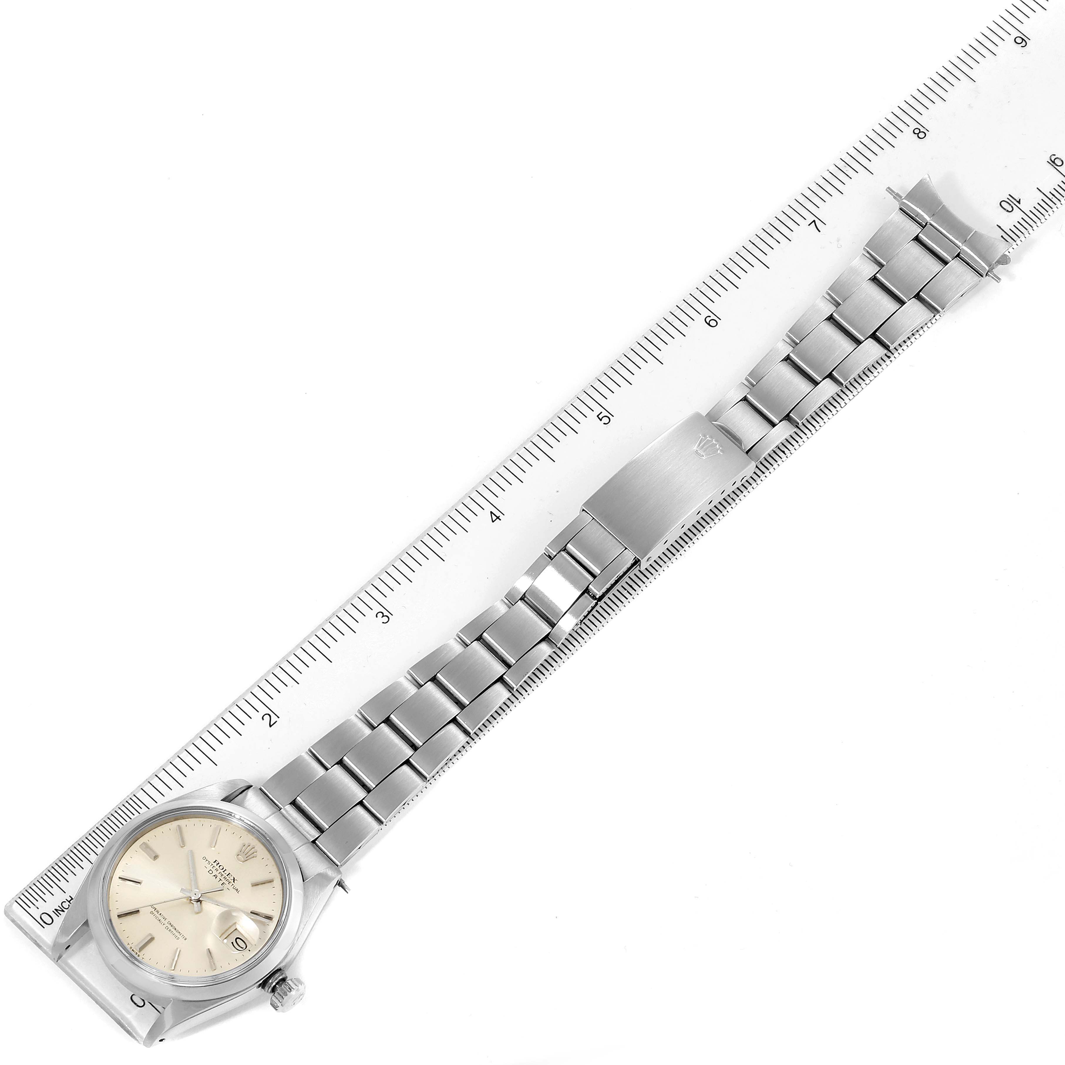 This image shows the Vintage Collection model by Rolex from a top-down angle, displaying the face, bracelet, and clasp alongside a centimeter ruler.