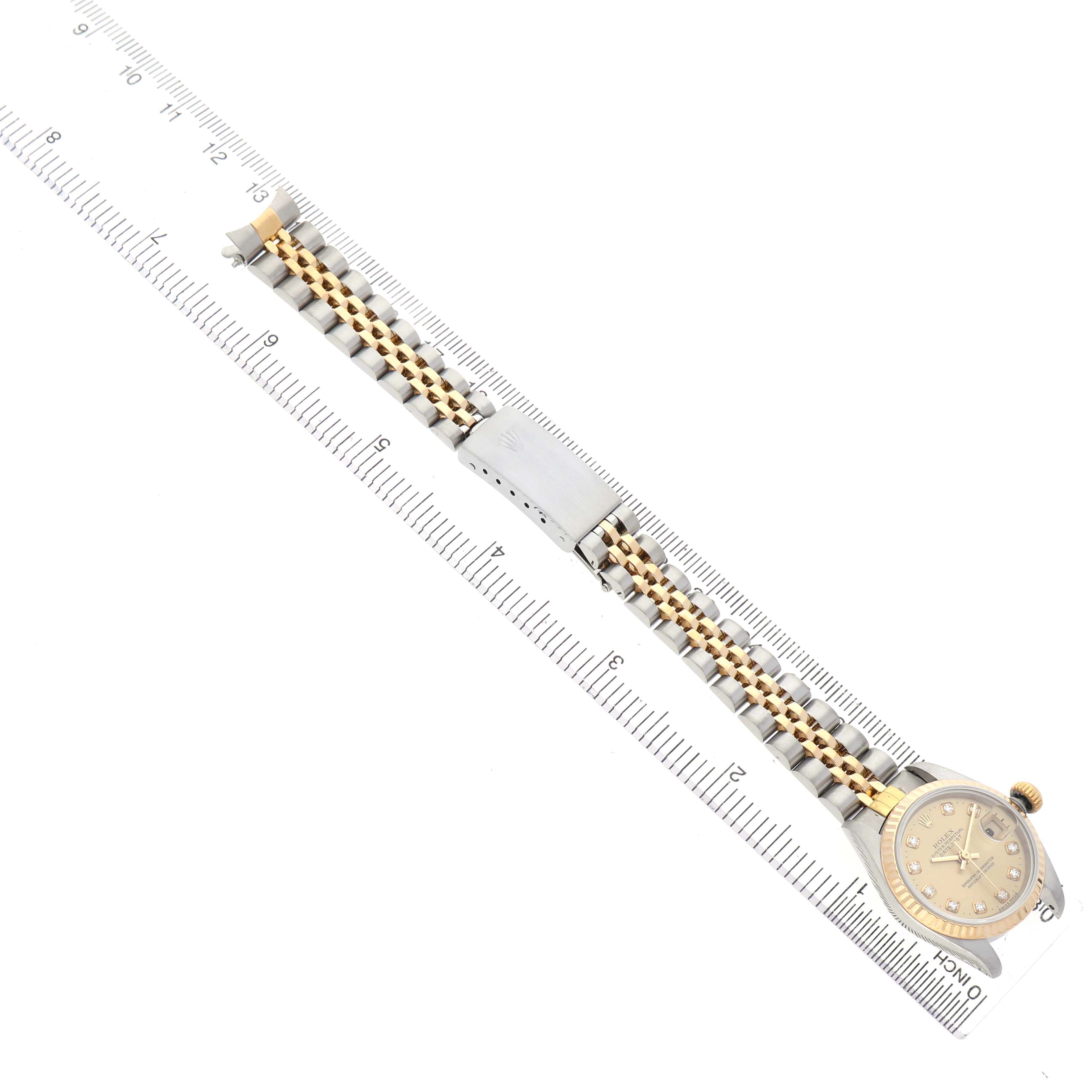 The Rolex Datejust 69173 Women's Steel and Gold (two tone) Champagne Dial watch is shown from an aerial view, featuring its full bracelet, clasp, and bezel.