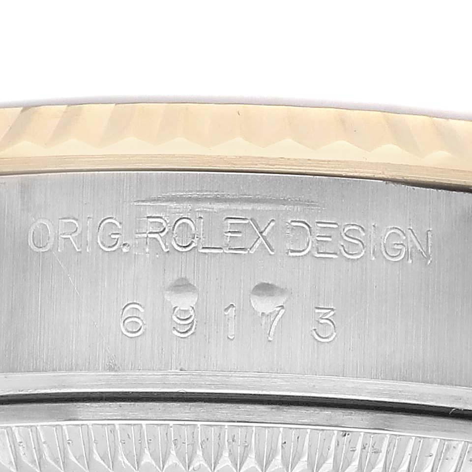 The image shows a close-up of the side of a Rolex Datejust 69173 Women's Steel and Gold (two tone) Champagne Dial, featuring the engraved reference number and design details.
