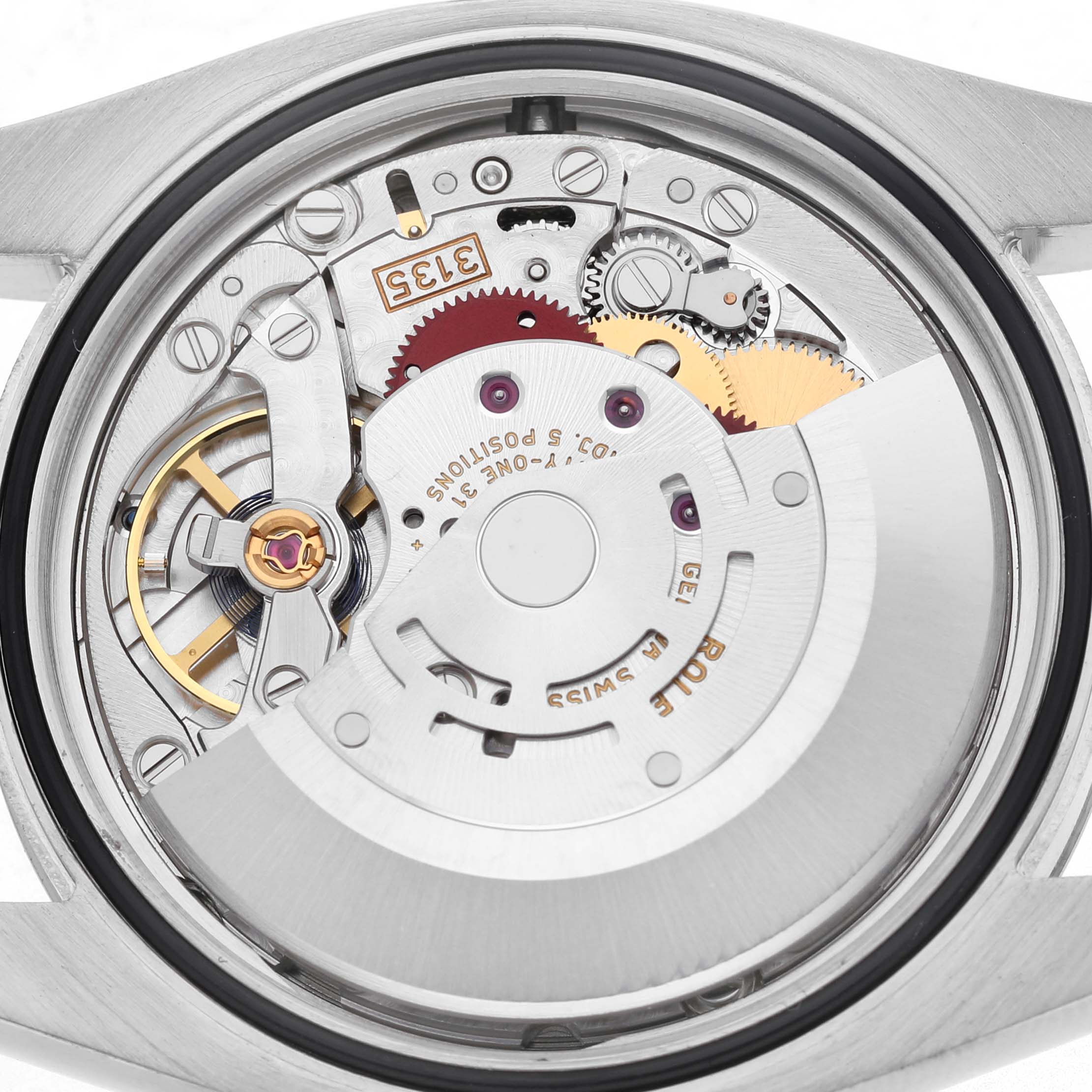 The image shows the movement mechanism from the back of the Rolex Datejust 116234 Men's Stainless Steel Silver Dial watch, highlighting gears and components.