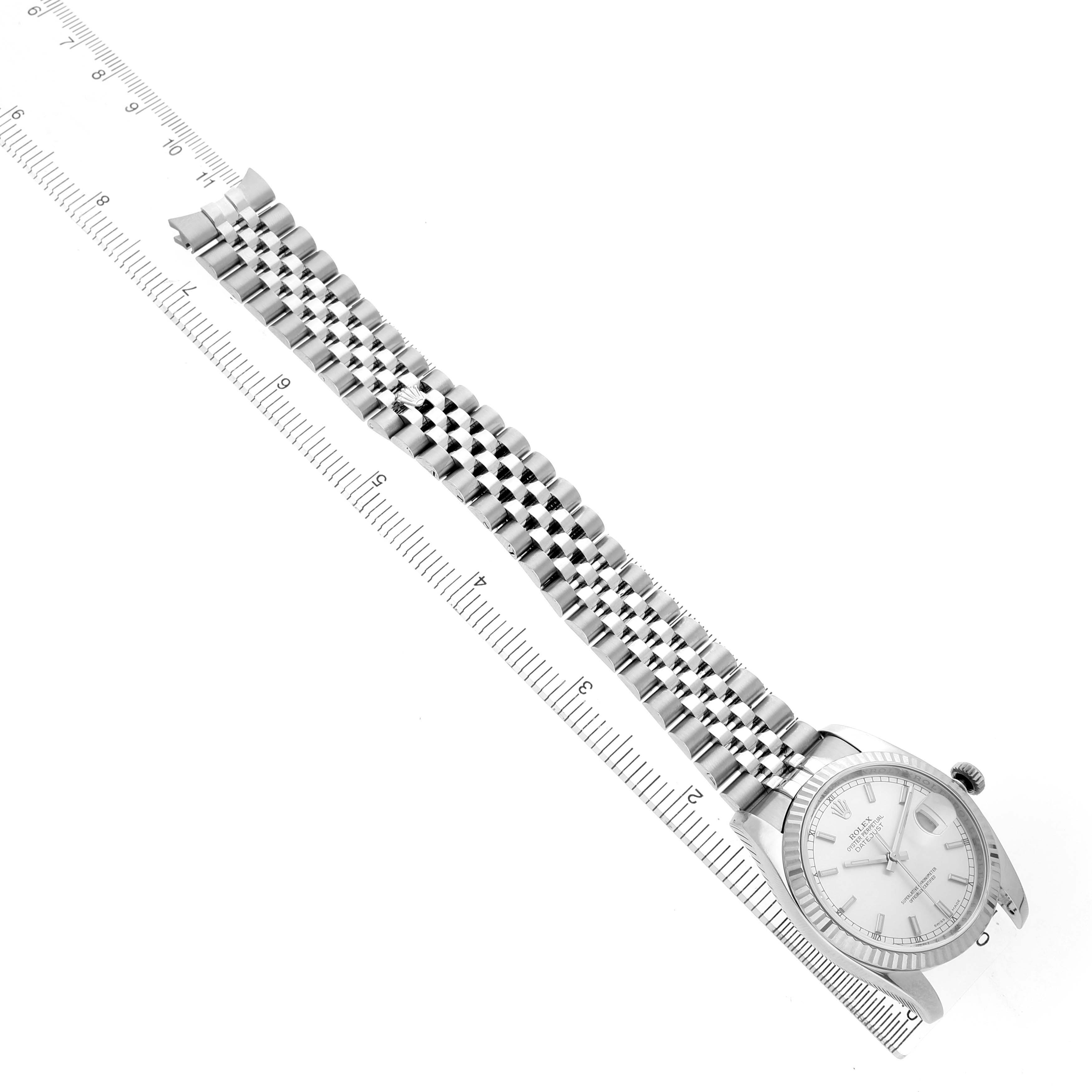 The Rolex Datejust 116234 Men's Stainless Steel Silver Dial watch is shown from a top view, displaying the full length of the bracelet and face next to a ruler.