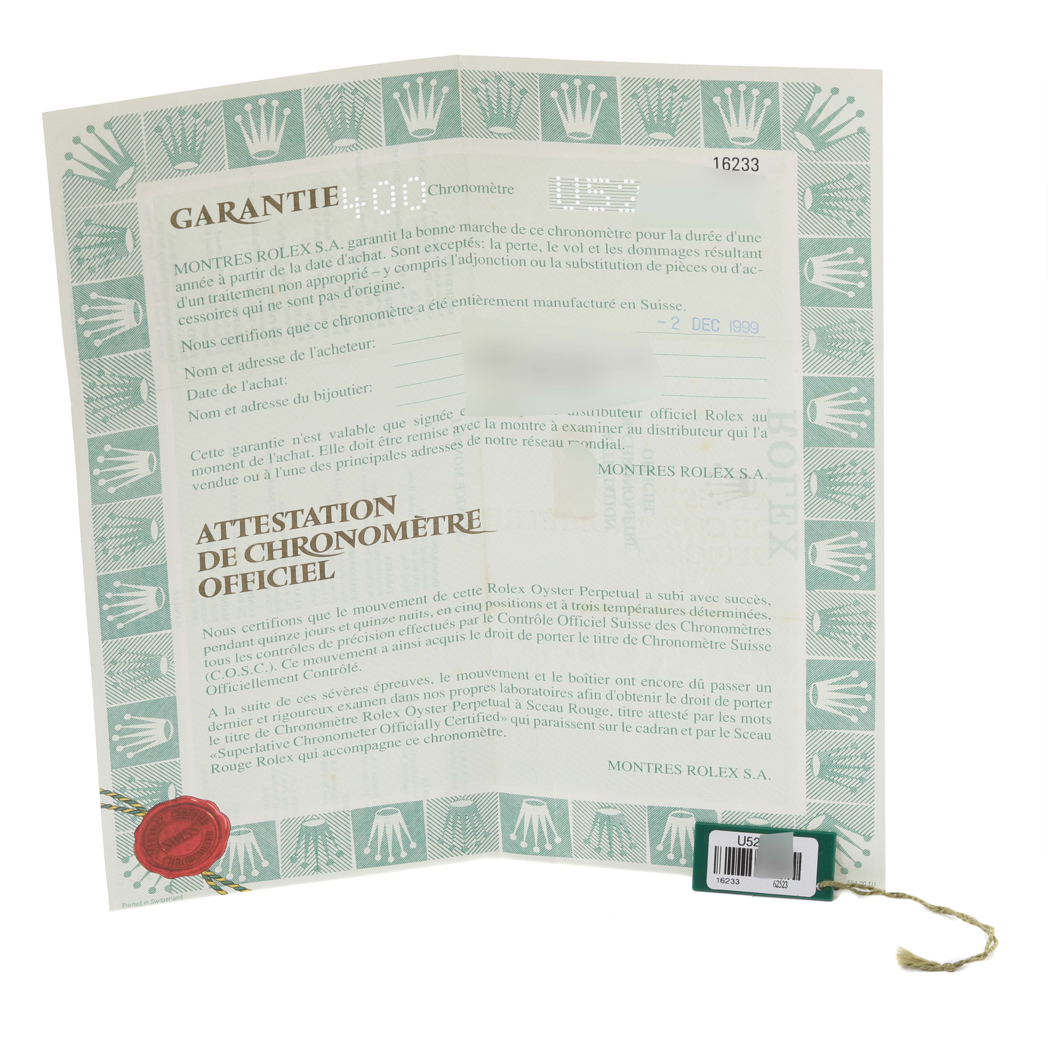 This image shows a guarantee certificate and tag for a Rolex Datejust 16233 Men's Steel and Gold (two tone) Black Dial 16233 Men's Steel and Gold (two tone) Black Dial watch, photographed from a straight-on angle.