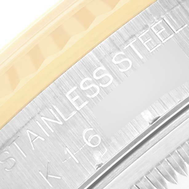 The image shows a close-up of the Rolex Datejust 16233 Men's Steel and Gold (two tone) Blue Dial 16233 Men's Steel and Gold (two tone) Blue Dial's stainless steel and gold fluted bezel and case with engraved text.