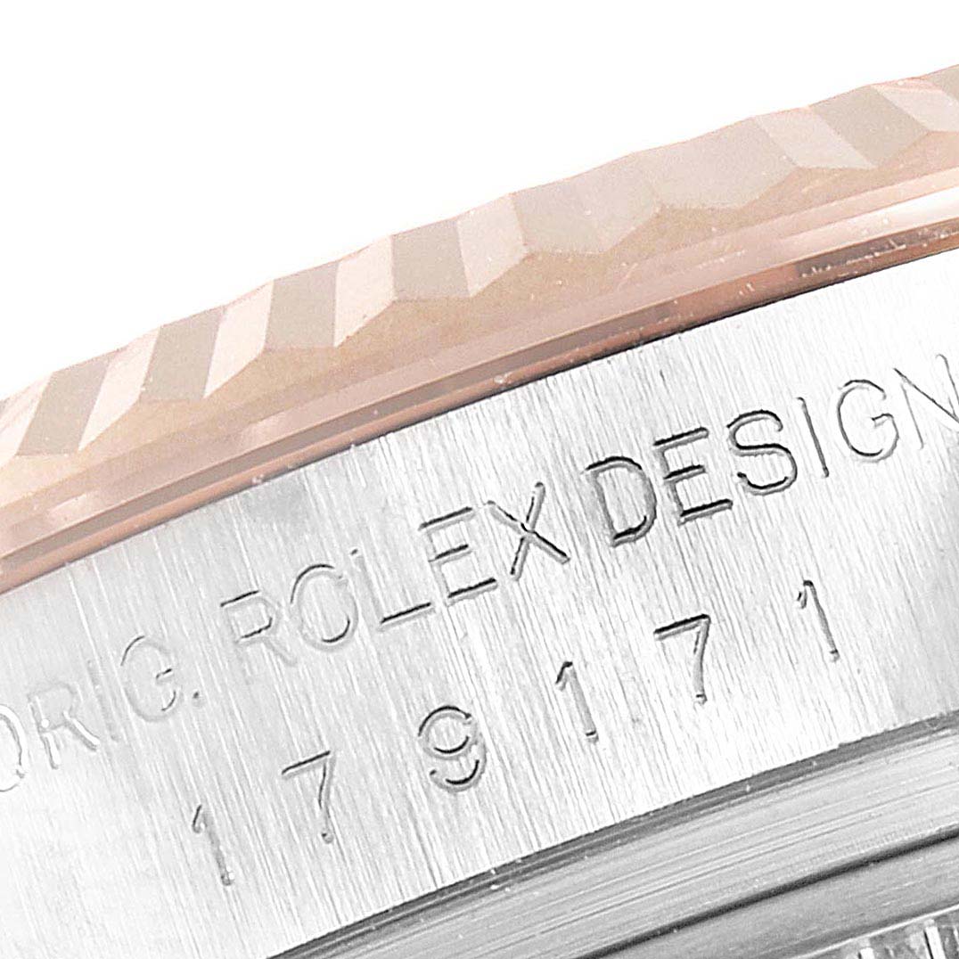 This is a close-up of the side of a Rolex Datejust 179171 Women's Steel and Gold (two tone) Pink Dial 179171 Women's Steel and Gold (two tone) Pink Dial watch, displaying its fluted bezel and engraved case.