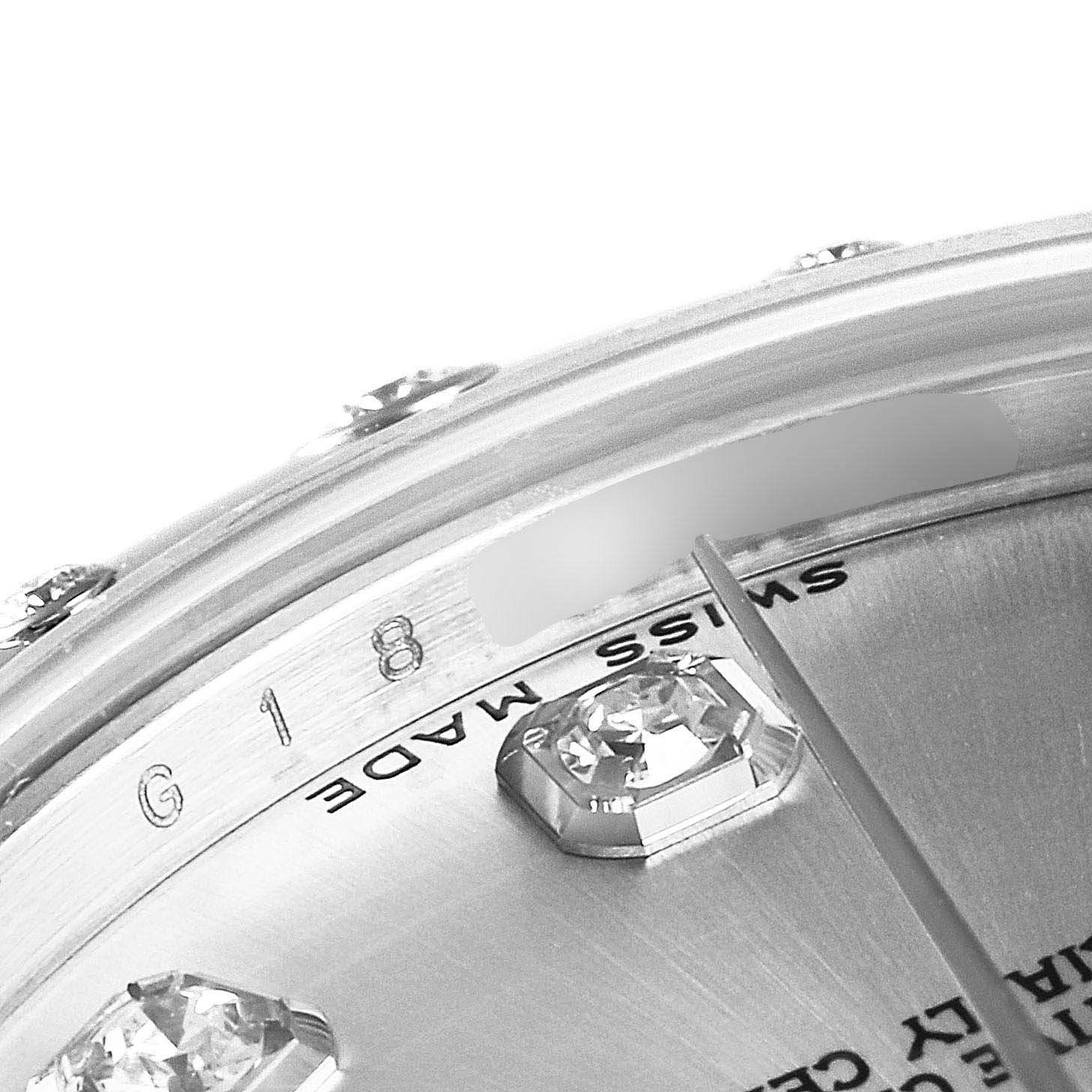 The image shows a close-up view of the dial and bezel of a mid-size Rolex watch, highlighting diamond markers and the "Swiss Made" inscription.