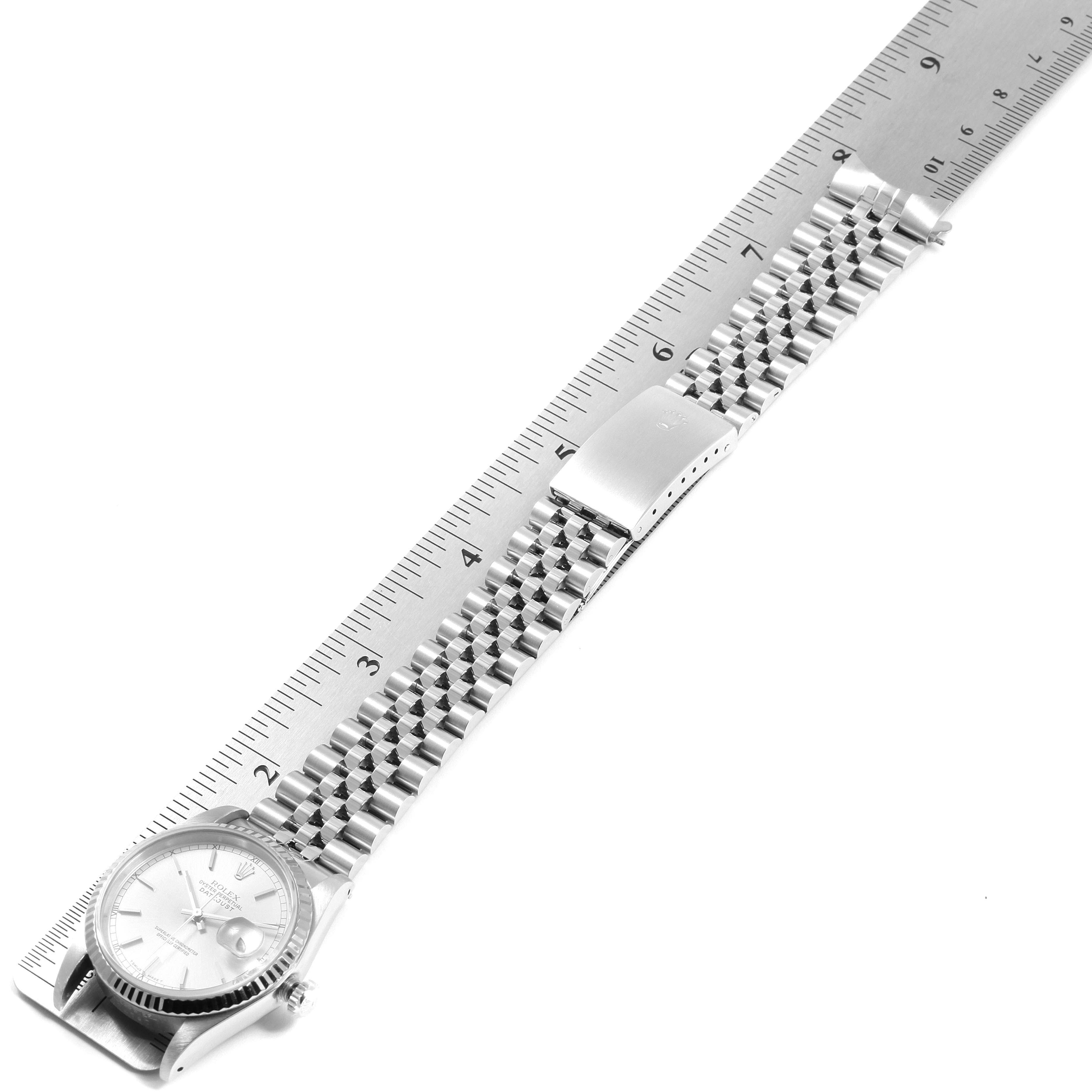 The image shows a Rolex Datejust 16234 Men's Stainless Steel Silver Dial 16234 Men's Stainless Steel Silver Dial watch placed on a ruler, highlighting its bracelet and clasp.