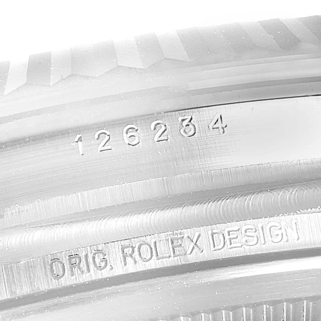 This is a close-up shot of the serial number and "ORIG. ROLEX DESIGN" engraving on the case of the Rolex Datejust 126234 Men's Stainless Steel Blue Dial 126234 Men's Stainless Steel Blue Dial watch.