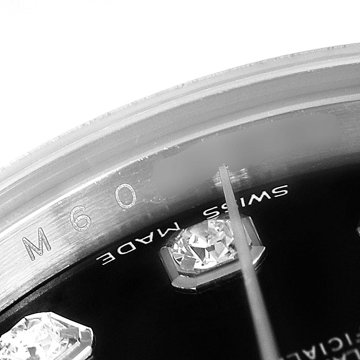 This close-up shot of a Rolex Datejust 79174 Women's Stainless Steel Black Dial 79174 Women's Stainless Steel Black Dial watch shows the details of the dial's gemstone, "Swiss Made" text, and part of the second hand.
