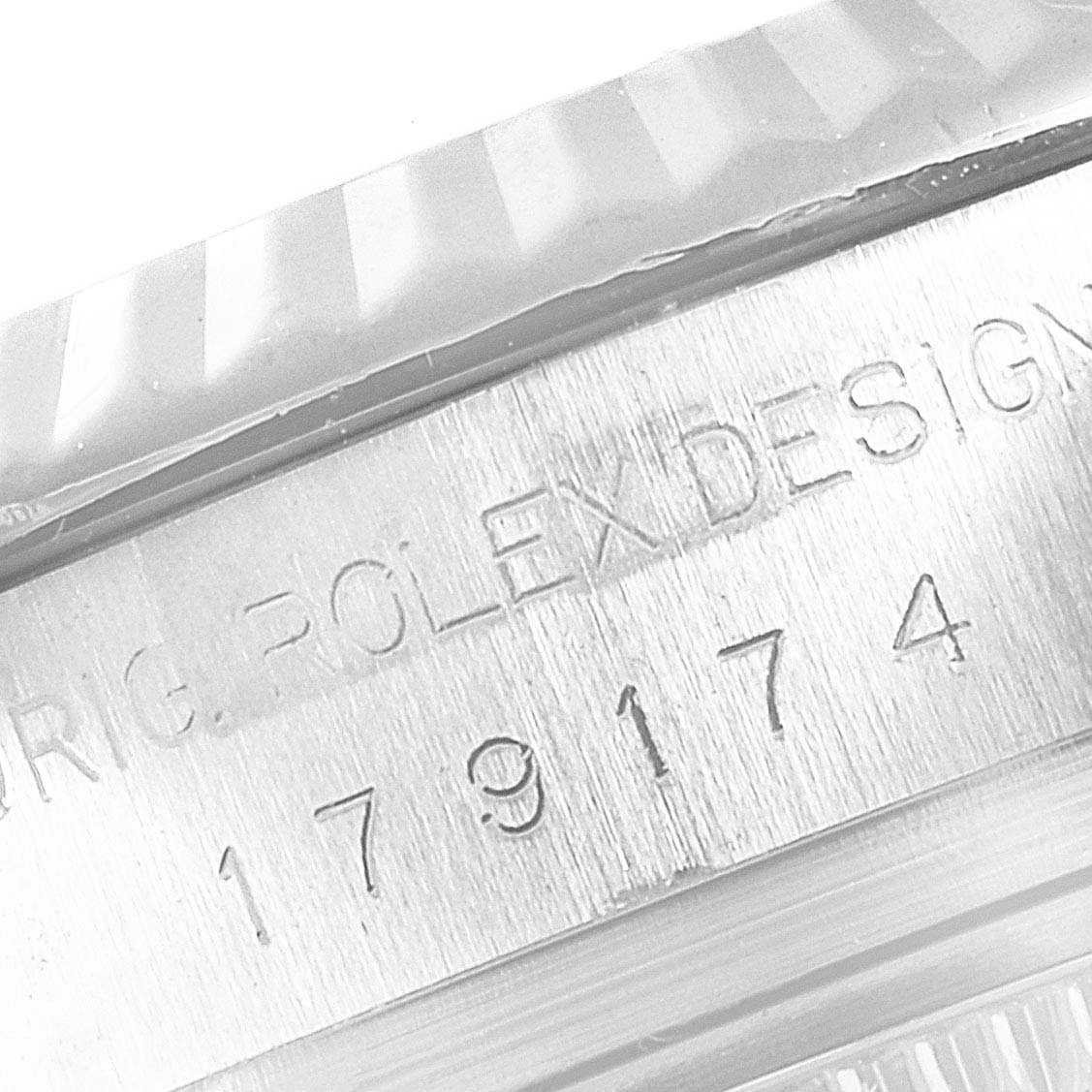 The image shows a close-up of the engraved model and serial number section on the side of the Rolex Datejust 79174 Women's Stainless Steel Black Dial 79174 Women's Stainless Steel Black Dial watch case.