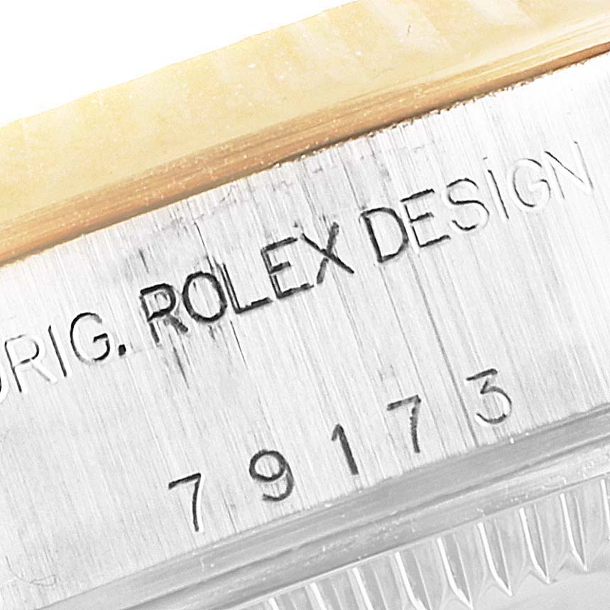 The image shows a close-up of the side engraving on the case of a Rolex Datejust 79173 Women
s Steel and Gold (two tone) Black Dial 79173 Women
s Steel and Gold (two tone) Black Dial watch.