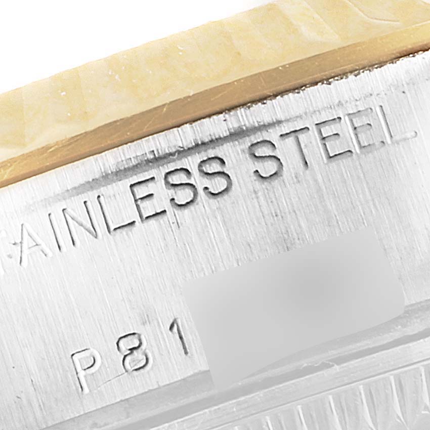 This image shows a close-up of the case back edge, revealing "STAINLESS STEEL" and part of the serial number of the Rolex Datejust 79173 Women's Steel and Gold (two tone) Champagne Dial 79173 Women's Steel and Gold (two tone) Champagne Dial.