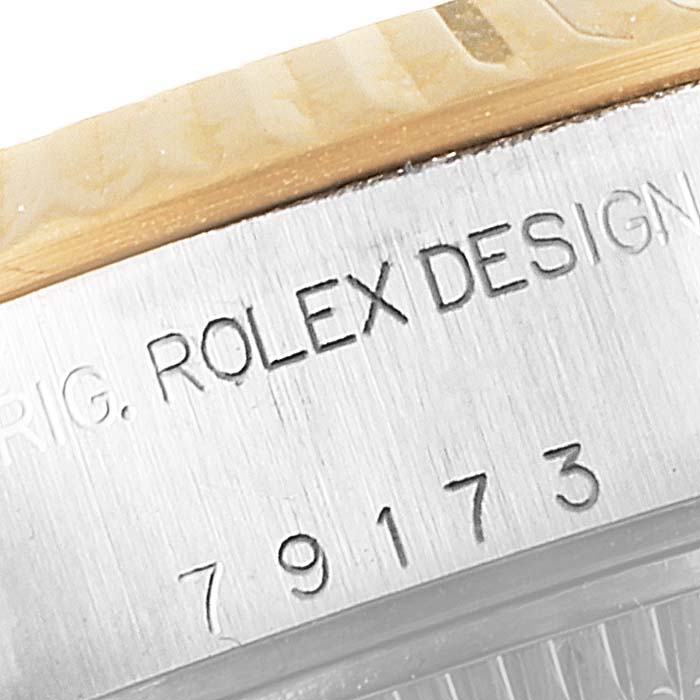 The image shows a close-up of the serial number and "ROLEX DESIGN" engraving on the side of a Rolex Datejust 79173 Women's Steel and Gold (two tone) Silver Dial 79173 Women's Steel and Gold (two tone) Silver Dial watch case.