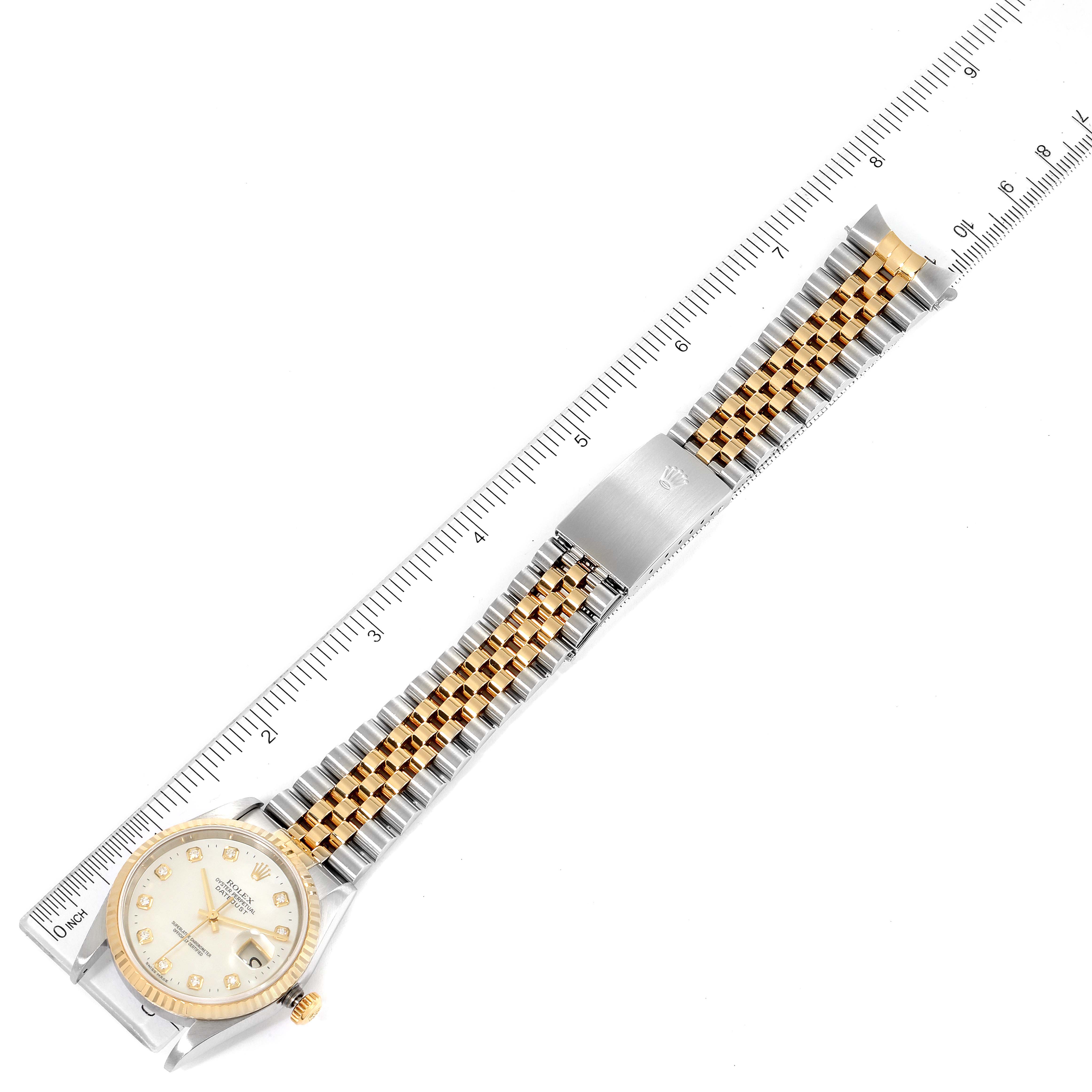 The Rolex Datejust 16233 Men's Steel and Gold (two tone) Mother of Pearl Dial 16233 Men's Steel and Gold (two tone) Mother of Pearl Dial watch is displayed flat with its face, band, and clasp visible next to a measuring scale.