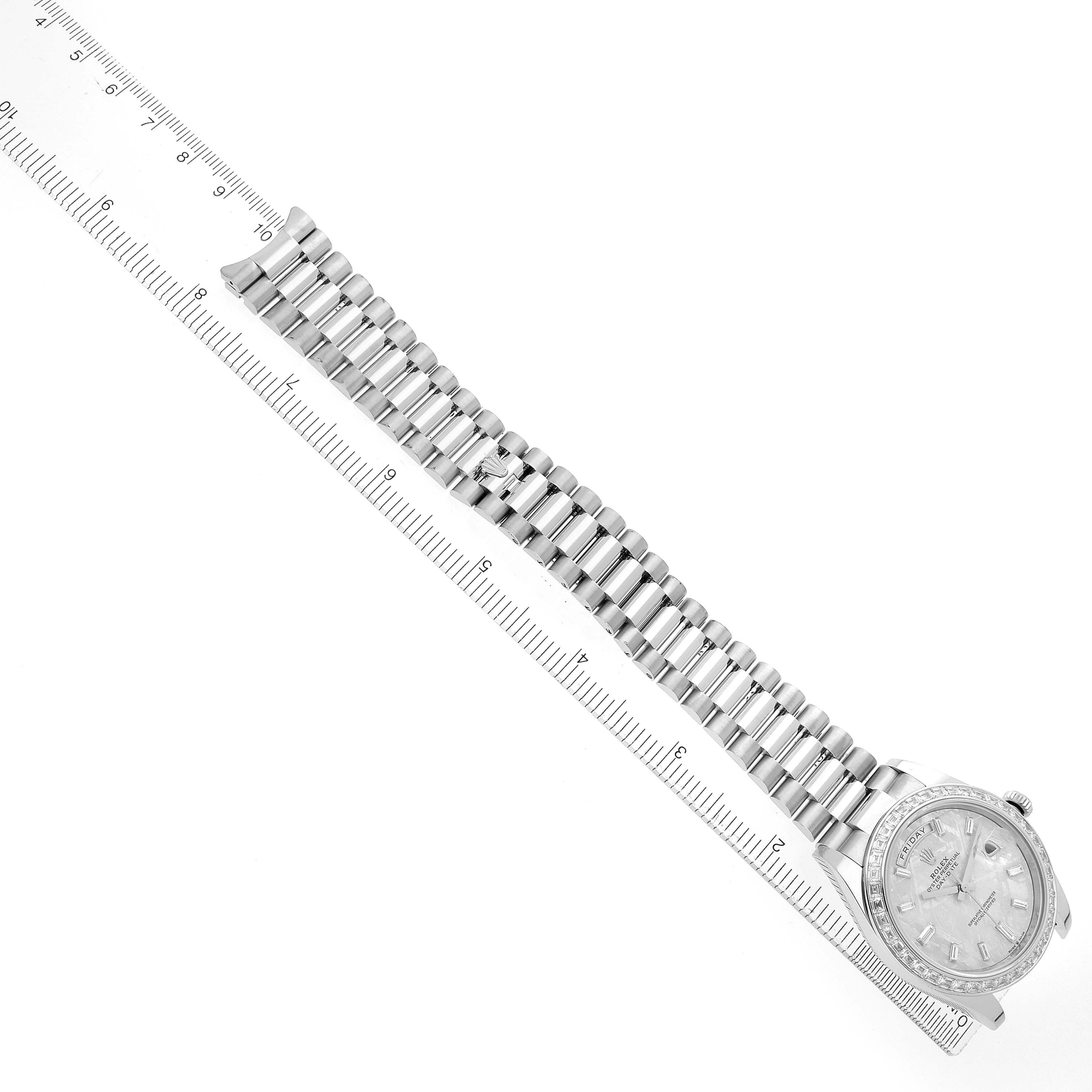 The Rolex President 228396 Men
s Platinum Silver Dial model watch is displayed from a top-down angle, showing the full bracelet and face along a ruler for scale.