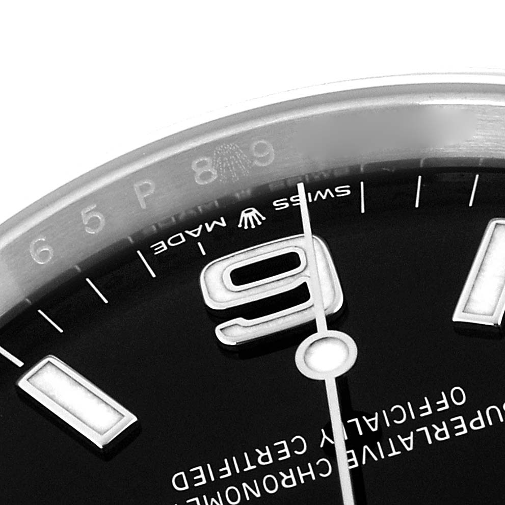 The image shows a close-up of a Rolex Explorer 124270 Men
s Stainless Steel Black Dial
s dial, focusing on the "9" numeral, part of the bezel, and "Swiss Made" text.