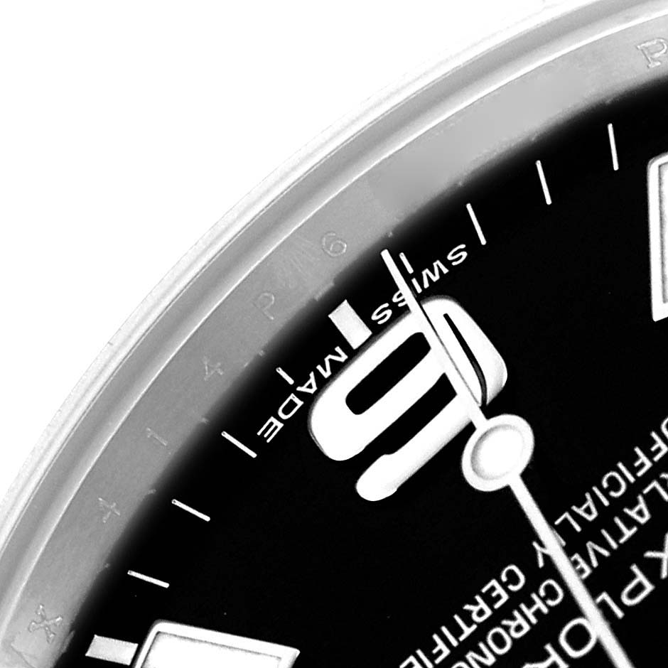 The image shows a close-up of the watch face on a Rolex Explorer 214270 Men
s Stainless Steel Black Dial, highlighting the numeral "6" and part of the minute hand.