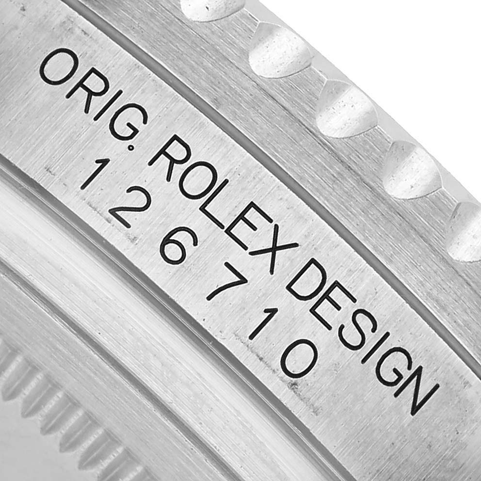 The image shows a close-up of the bezel and engraved design number of a Rolex GMT-Master 126710 Men's Stainless Steel Black Dial watch.