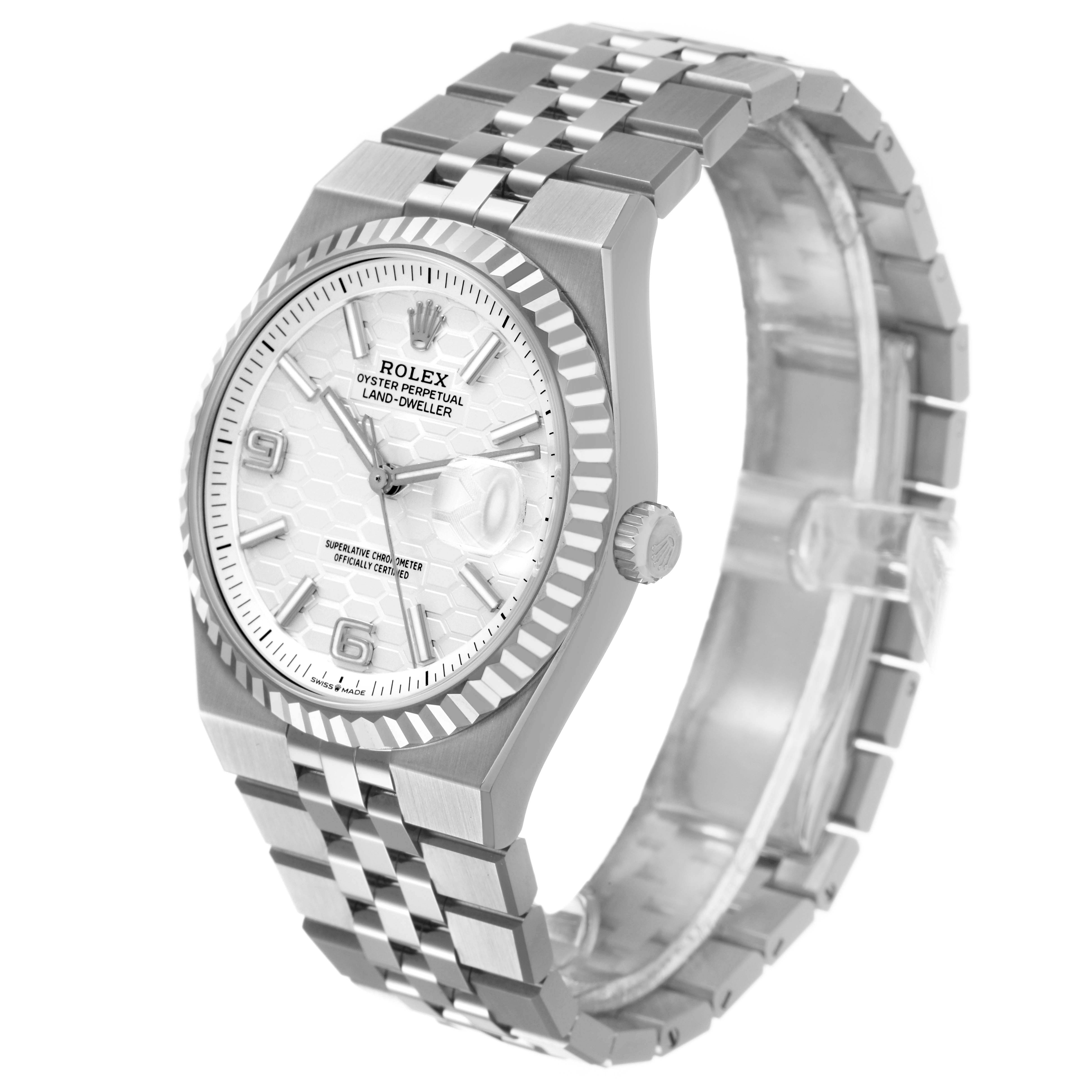 The Rolex Land-Dweller watch is shown at a three-quarter angle, displaying the face, bezel, crown, and bracelet.
