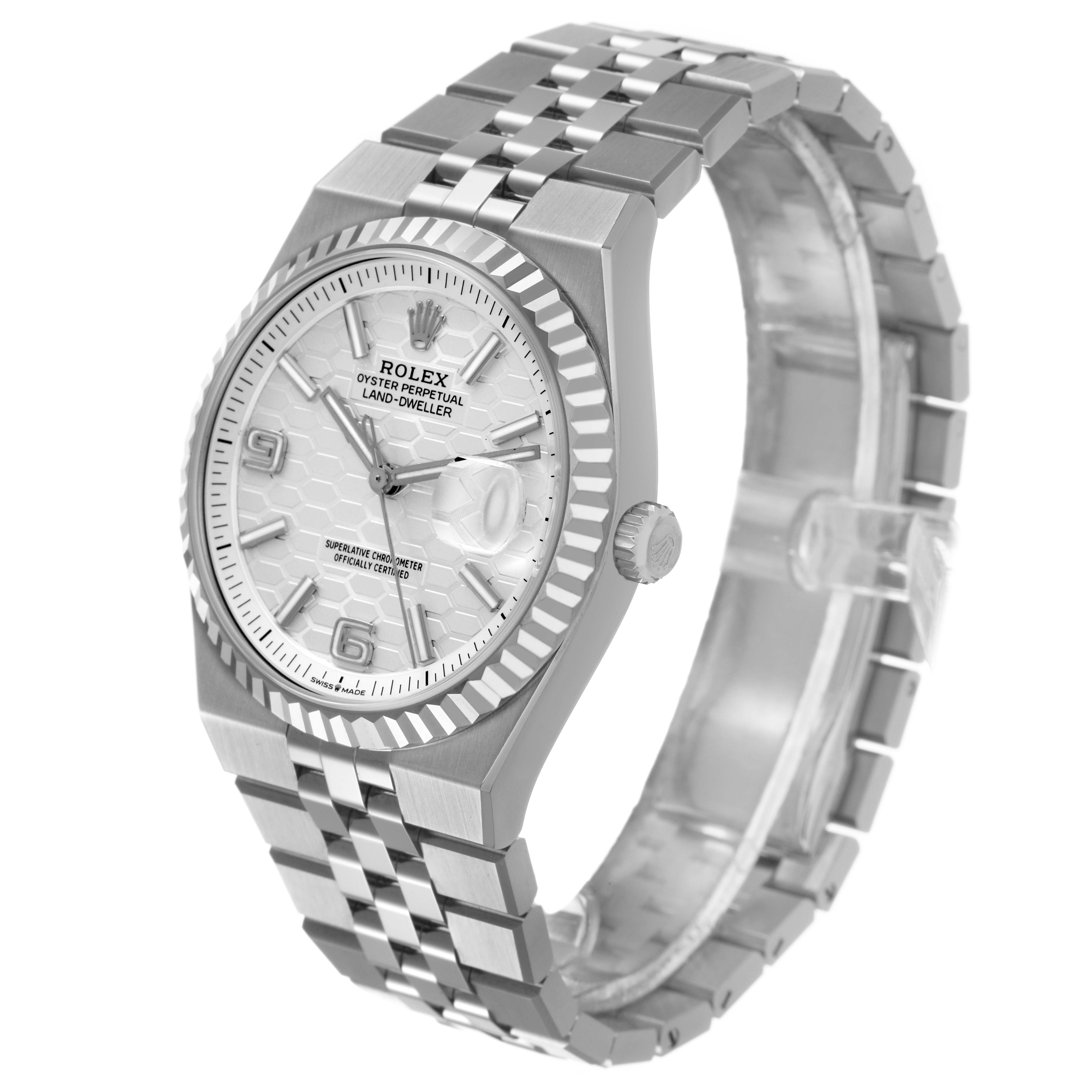 The Rolex Land-Dweller watch is shown at a three-quarter angle, highlighting the dial, bezel, case, and bracelet.