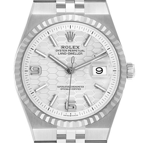 The Rolex Land-Dweller watch is shown from a front angle, highlighting the dial, bezel, and bracelet.