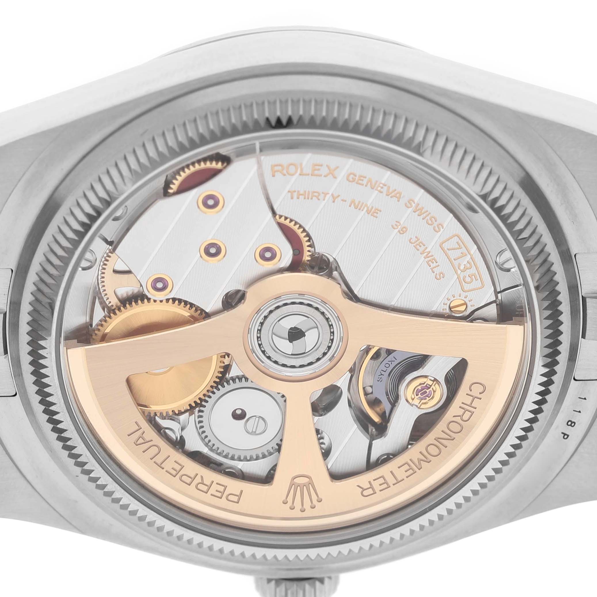 The image shows a close-up view of the movement inside a Rolex Land-Dweller watch, highlighting gears and the rotor.
