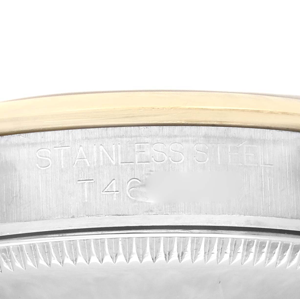 The image shows a close-up of the side of a Rolex Mid-Size 67483 Women's Steel and Gold (two tone) Grey Dial 67483 Women's Steel and Gold (two tone) Grey Dial model, displaying the edge of the case and an engraving indicating stainless steel material.