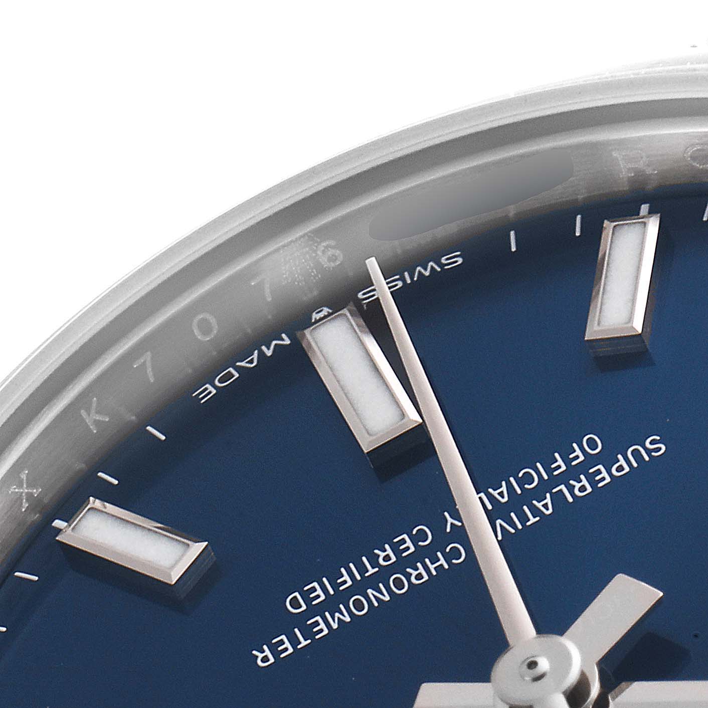 This close-up shot of the mid-size Rolex watch shows a partial view of the blue dial, hour markers, and hands.