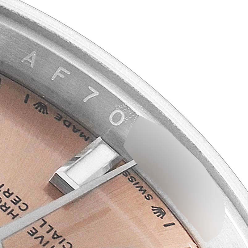 This close-up angle of the Rolex Oyster Perpetual 276200 Women
s Stainless Steel Pink Dial 276200 Women
s Stainless Steel Pink Dial watch shows part of the dial, a watch hand, and the inner bezel with engravings.