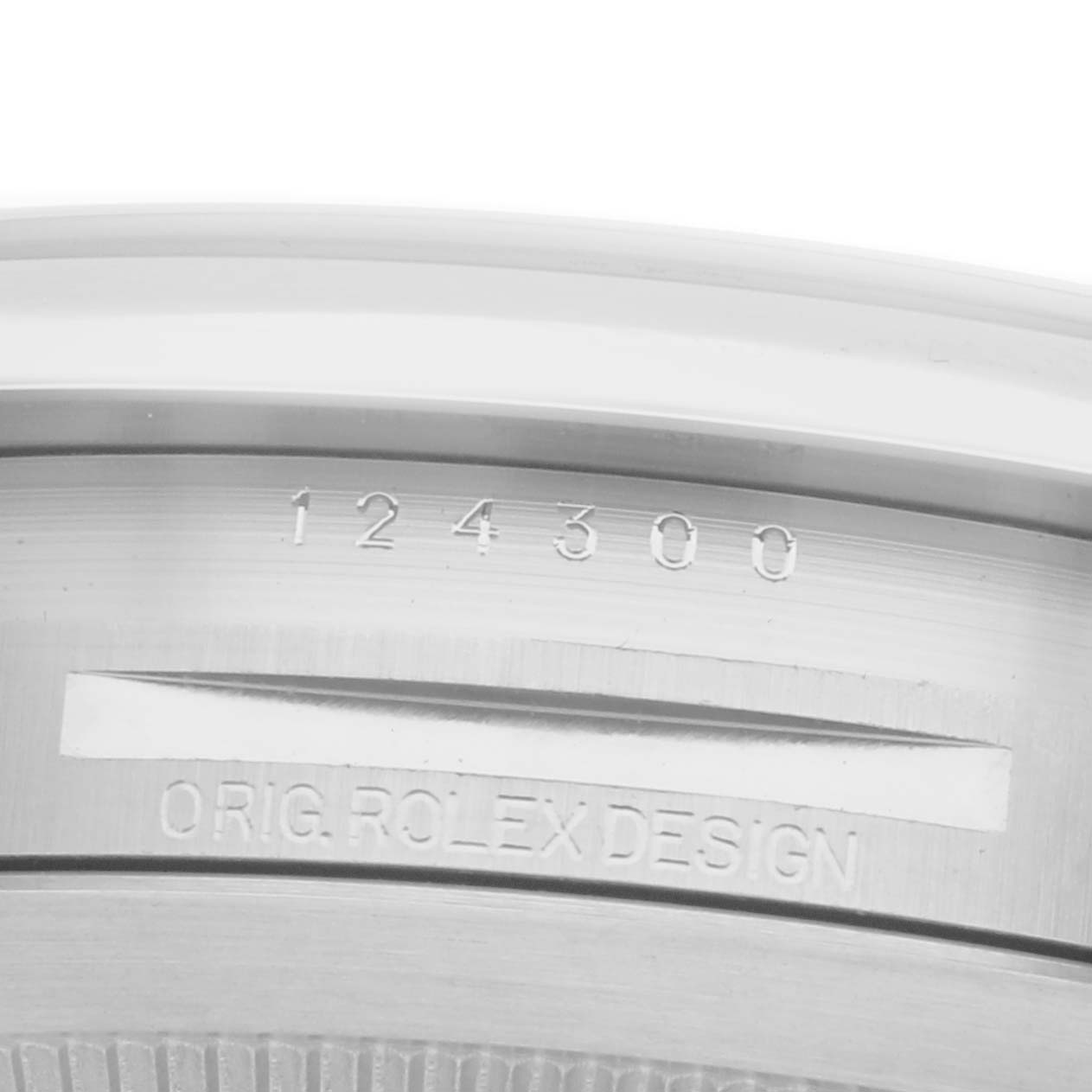 The image shows the serial number and "ORIG. ROLEX DESIGN" engraving on the Oyster Perpetual model by Rolex, viewed from the side.