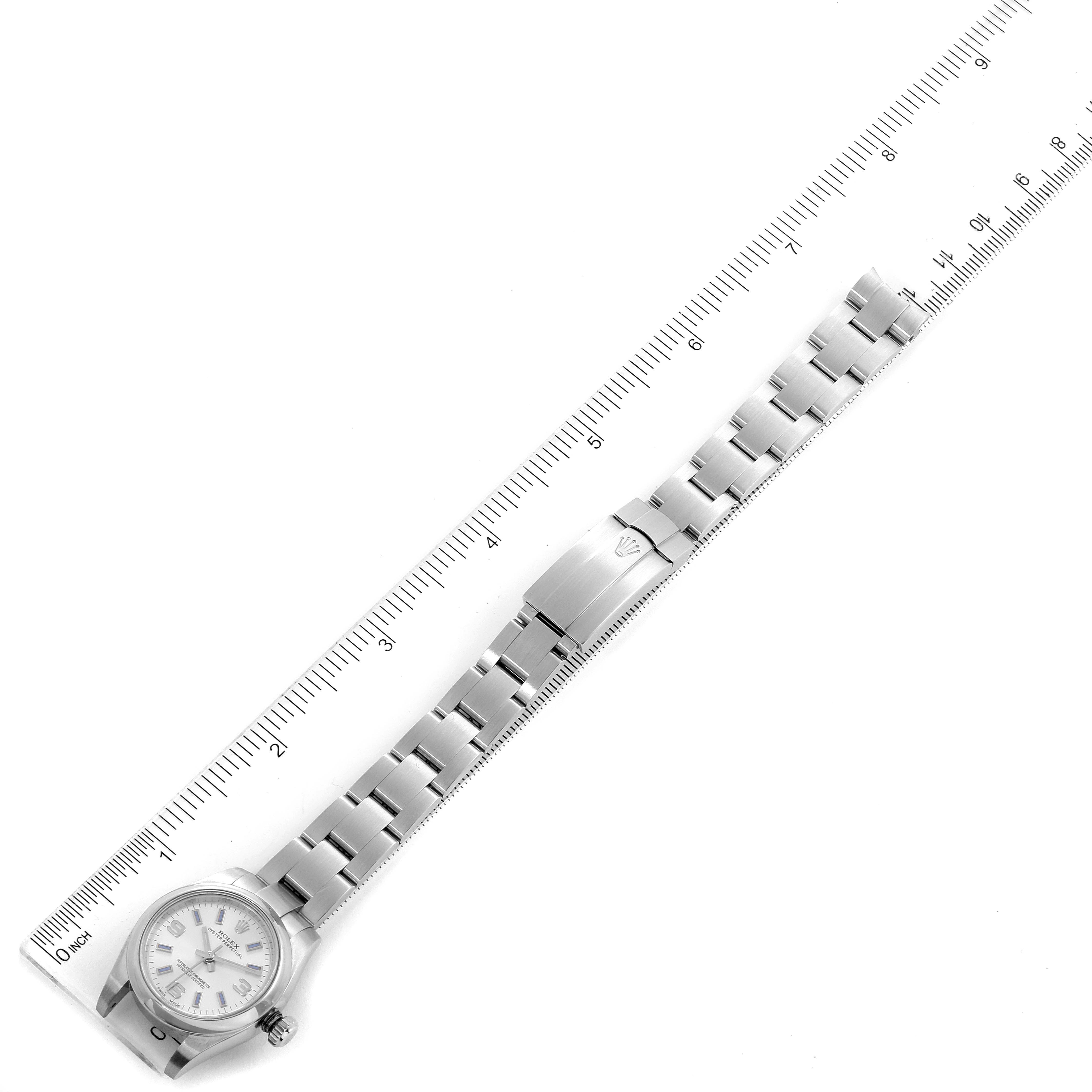 The Rolex Oyster Perpetual 176200 Women's Stainless Steel Silver Dial 176200 Women's Stainless Steel Silver Dial watch is shown from a top-down angle, with the full bracelet laid flat and a ruler for scale.