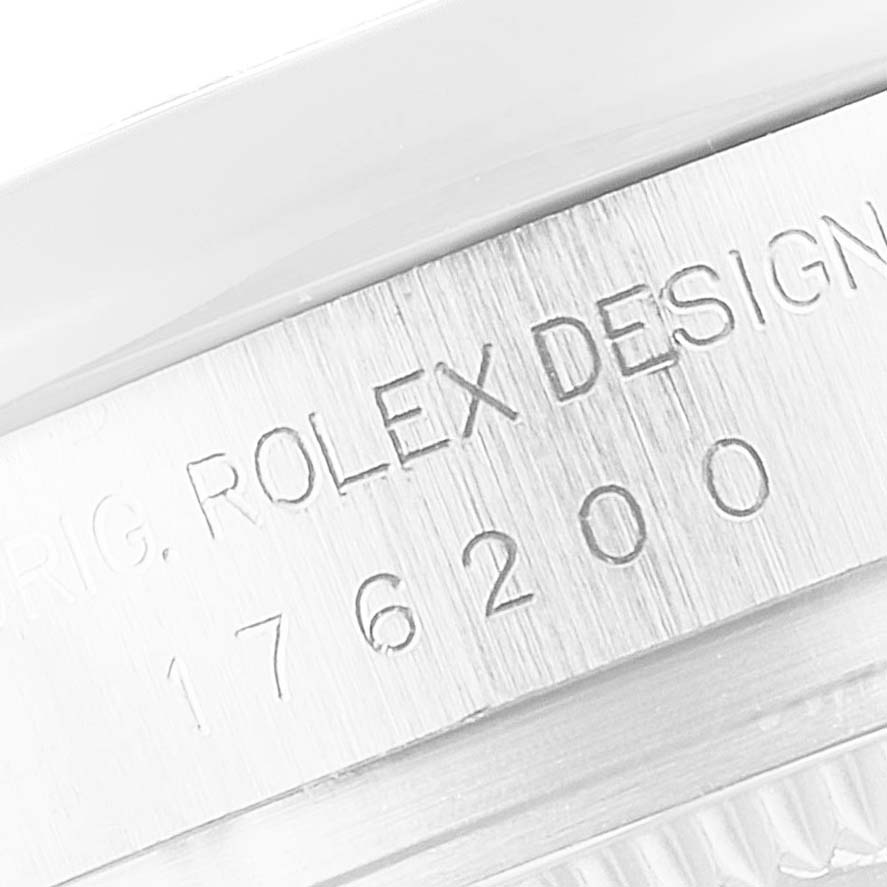 The image shows a close-up of the engraved serial number and "Rolex Design" text on the watch case of a Rolex Oyster Perpetual 176200 Women's Stainless Steel Silver Dial 176200 Women's Stainless Steel Silver Dial.