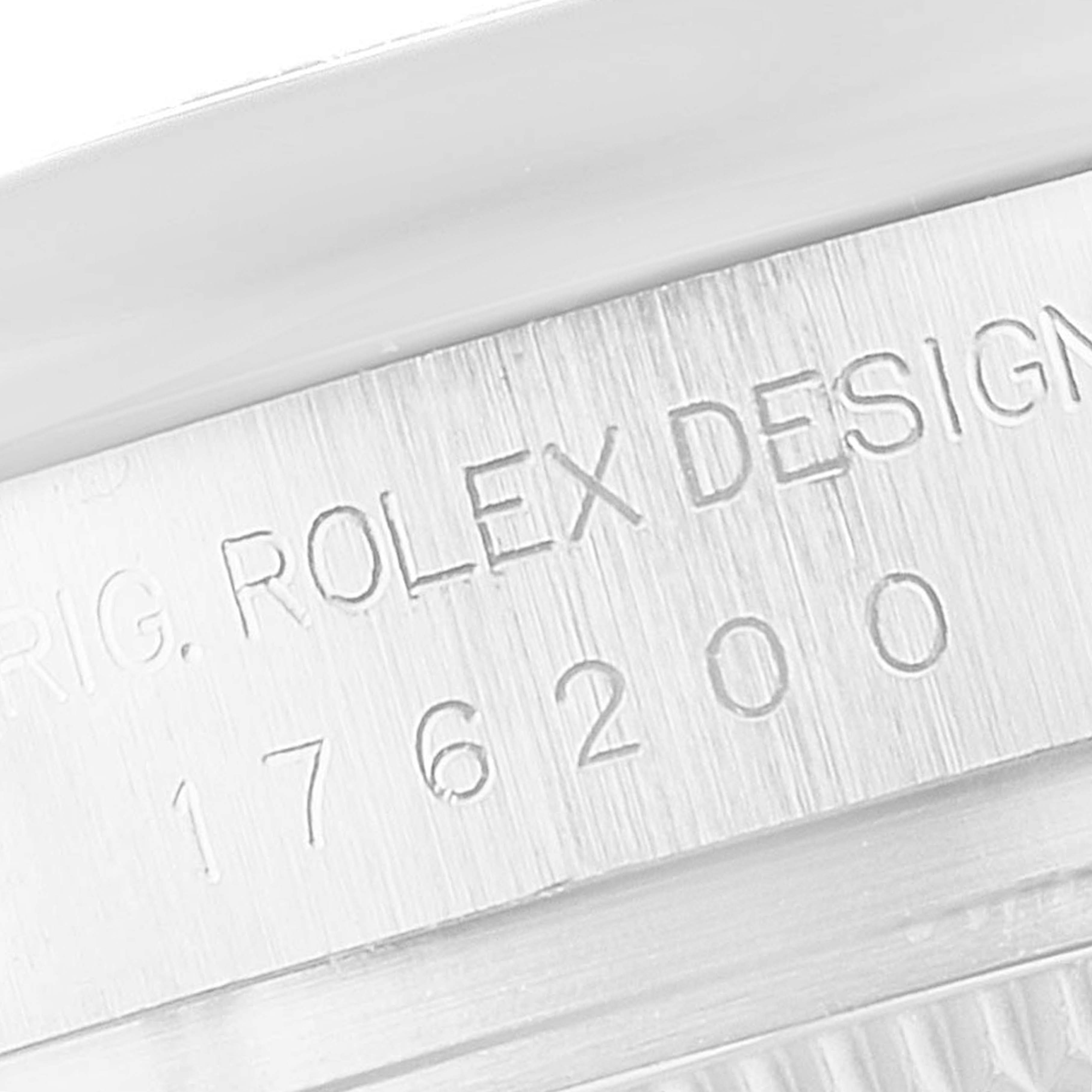 The image shows a close-up of the serial number and "Rolex Design" engraving on the Oyster Perpetual model by Rolex.