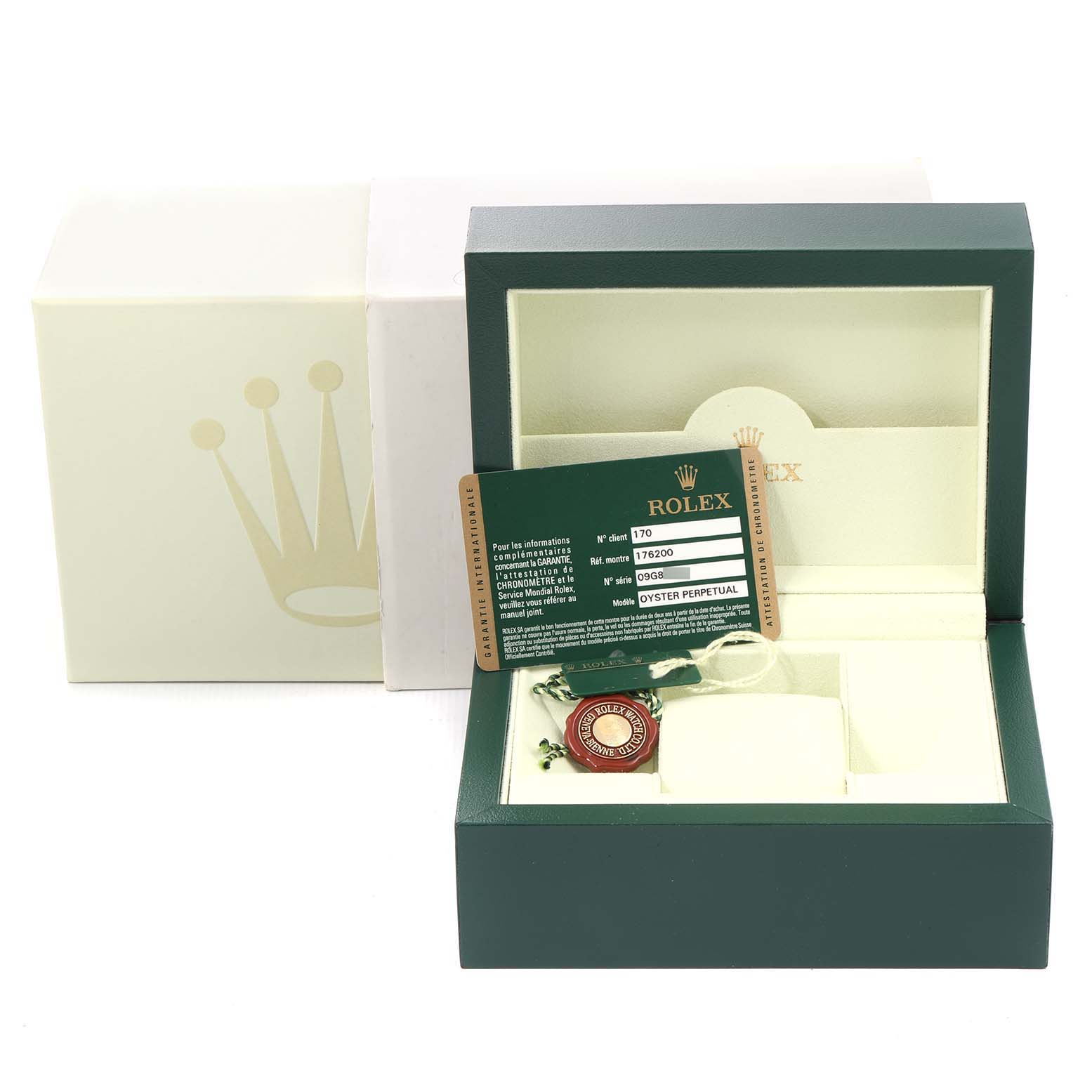The image shows an open Rolex box for the Oyster Perpetual model, displaying its tag and warranty card.
