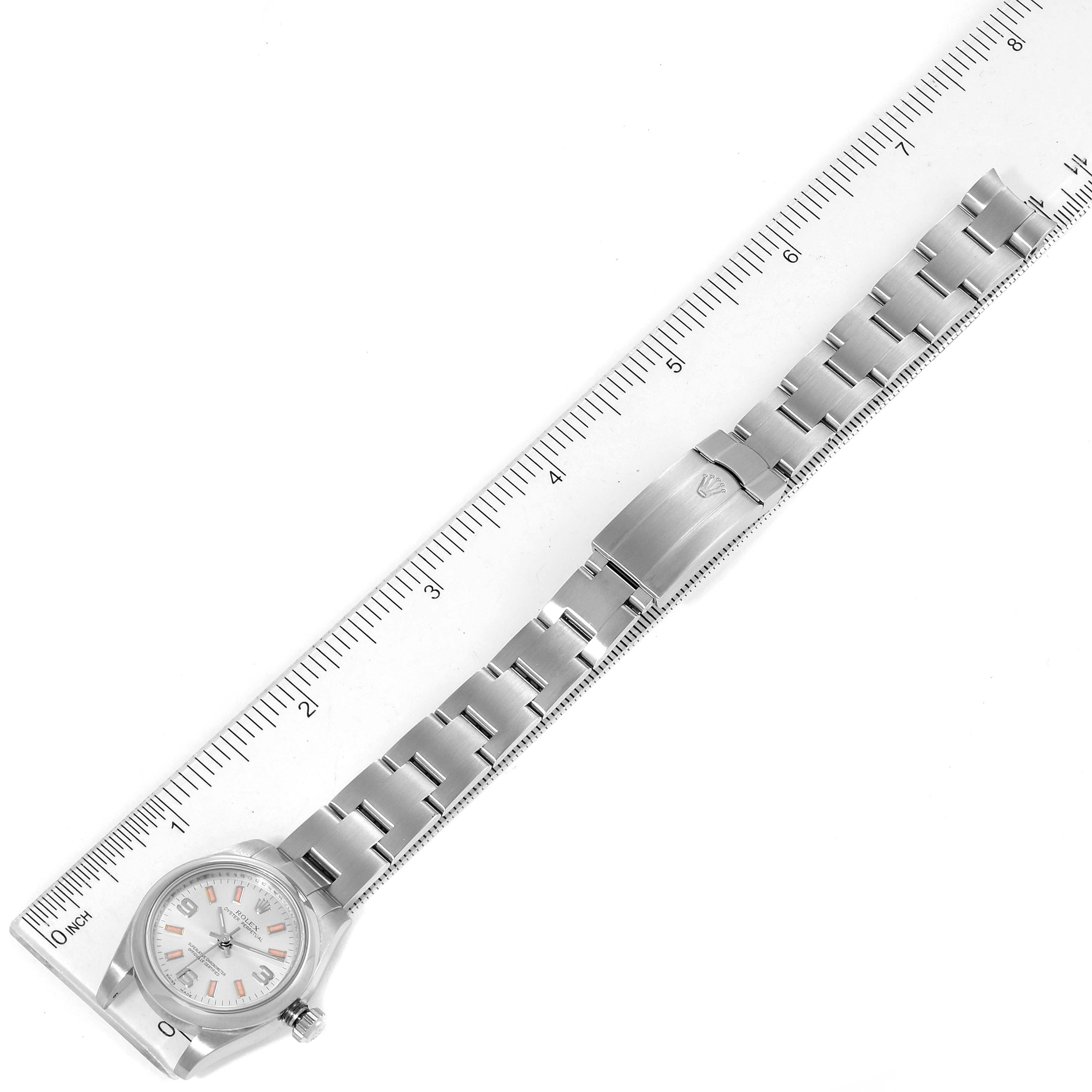 This image shows a top-down view of a Rolex Oyster Perpetual 176200 Women's Stainless Steel Silver Dial 176200 Women's Stainless Steel Silver Dial watch, highlighting its metal bracelet and clasp against a ruler.
