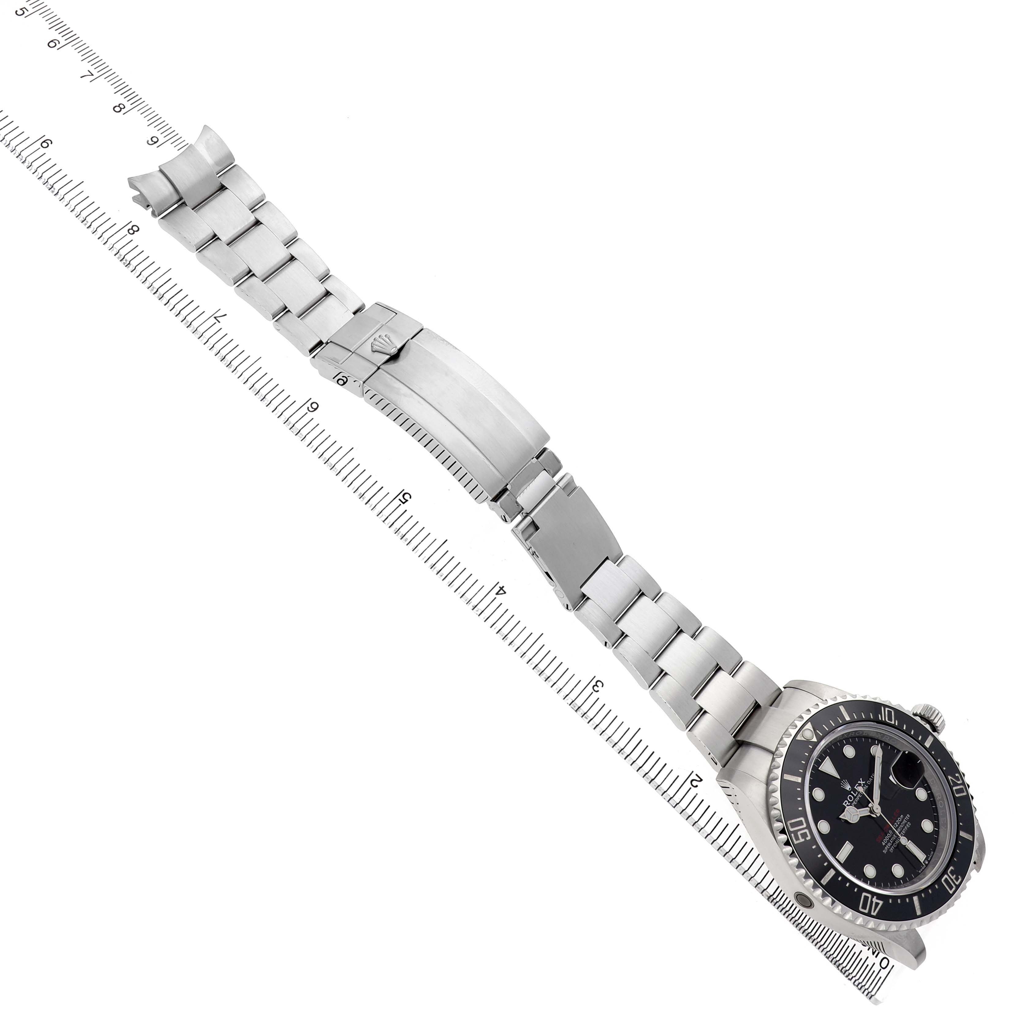 The Rolex Sea-Dweller 126600 Men's Stainless Steel Black Dial watch is displayed at an angle, showing the black dial, bezel, stainless steel bracelet, and clasp with a ruler.