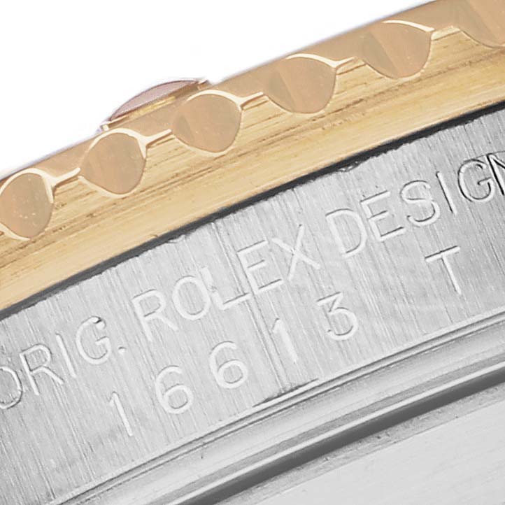 This close-up image of a Rolex Submariner 16613 Men's Steel and Gold (two tone) Blue Dial 16613 Men's Steel and Gold (two tone) Blue Dial shows part of the bezel and the engraved model number on the case.