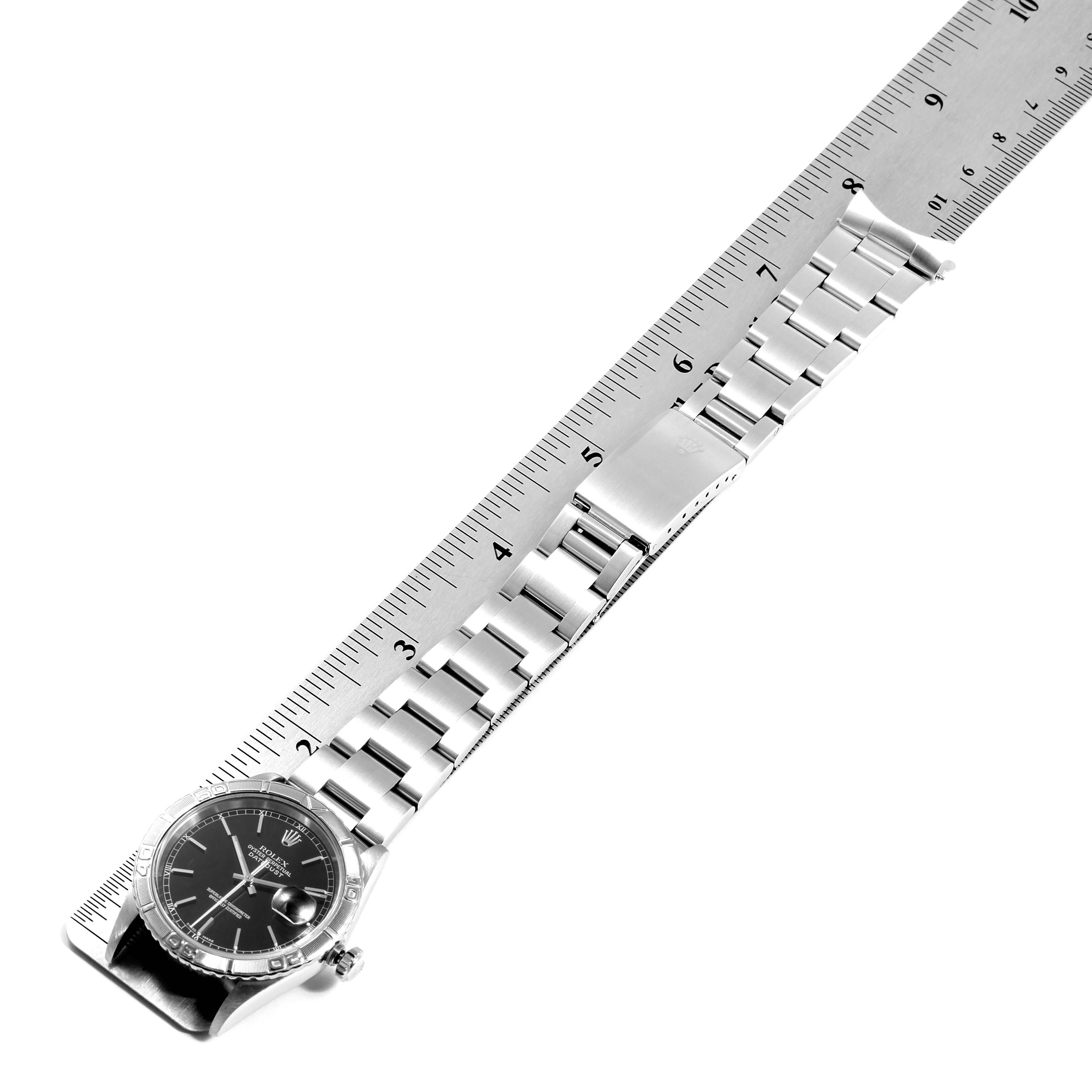 The image shows a Rolex Turn-o-Graph 16264 Men
s Stainless Steel Black Dial 16264 Men
s Stainless Steel Black Dial watch laid flat with its bracelet measured against a ruler.