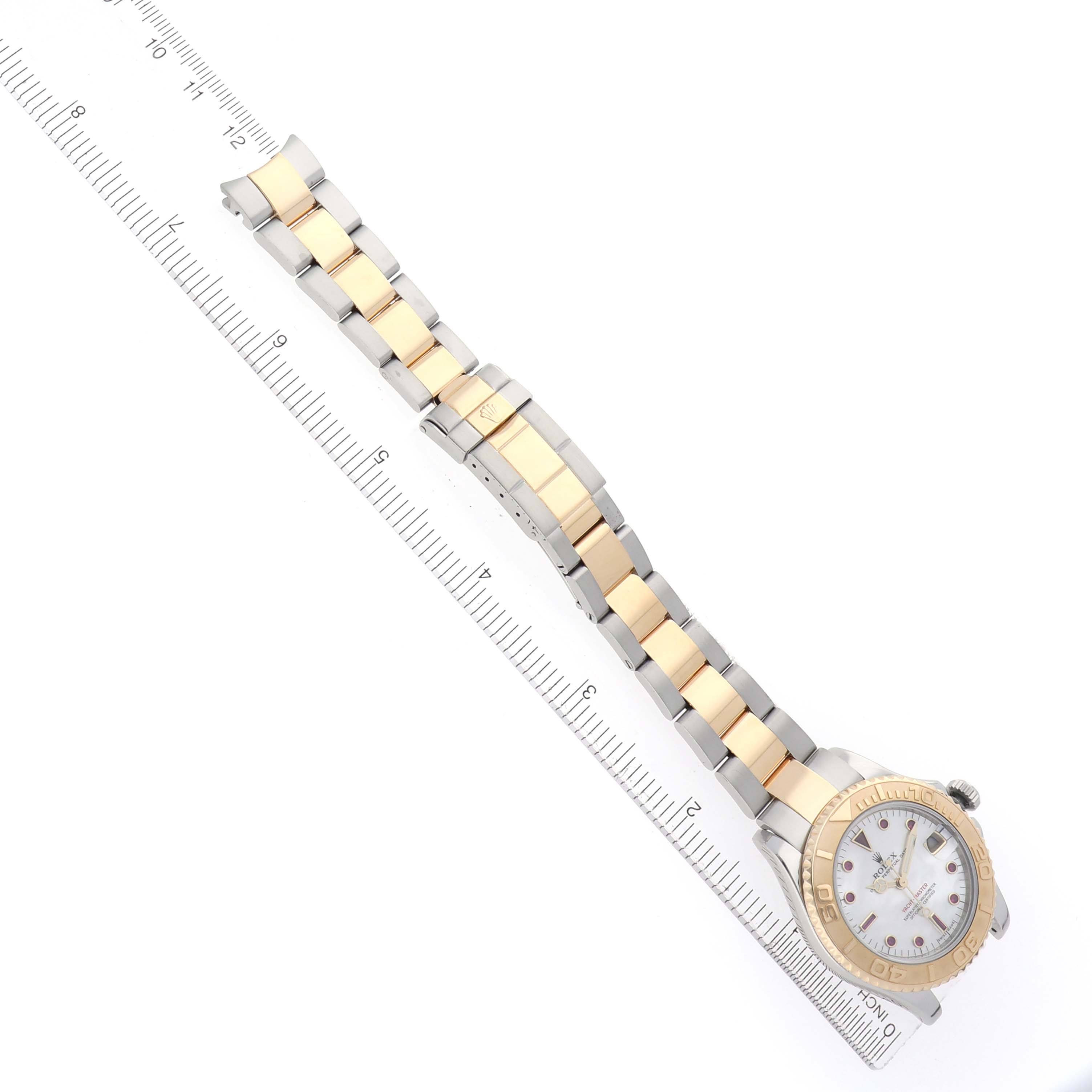 The Rolex Yacht-Master 168623 Men
s Steel and Gold (two tone) Mother of Pearl Dial watch is displayed from a top view, showing the full bracelet and face alongside a ruler for scale.