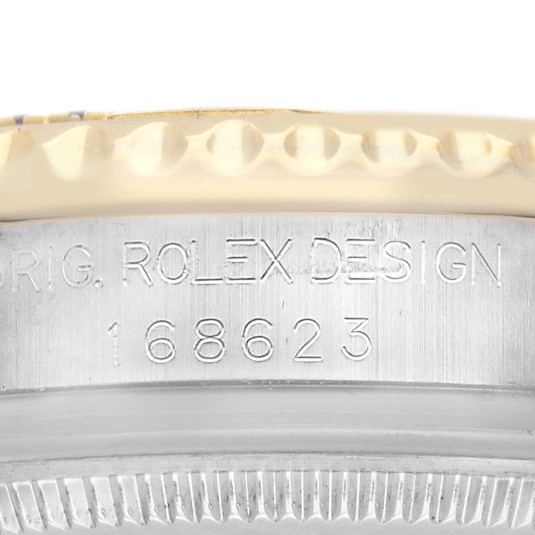 The image shows a close-up of the side of a Rolex Yacht-Master 168623 Men
s Steel and Gold (two tone) Mother of Pearl Dial watch, focusing on the bezel and engraved model number.