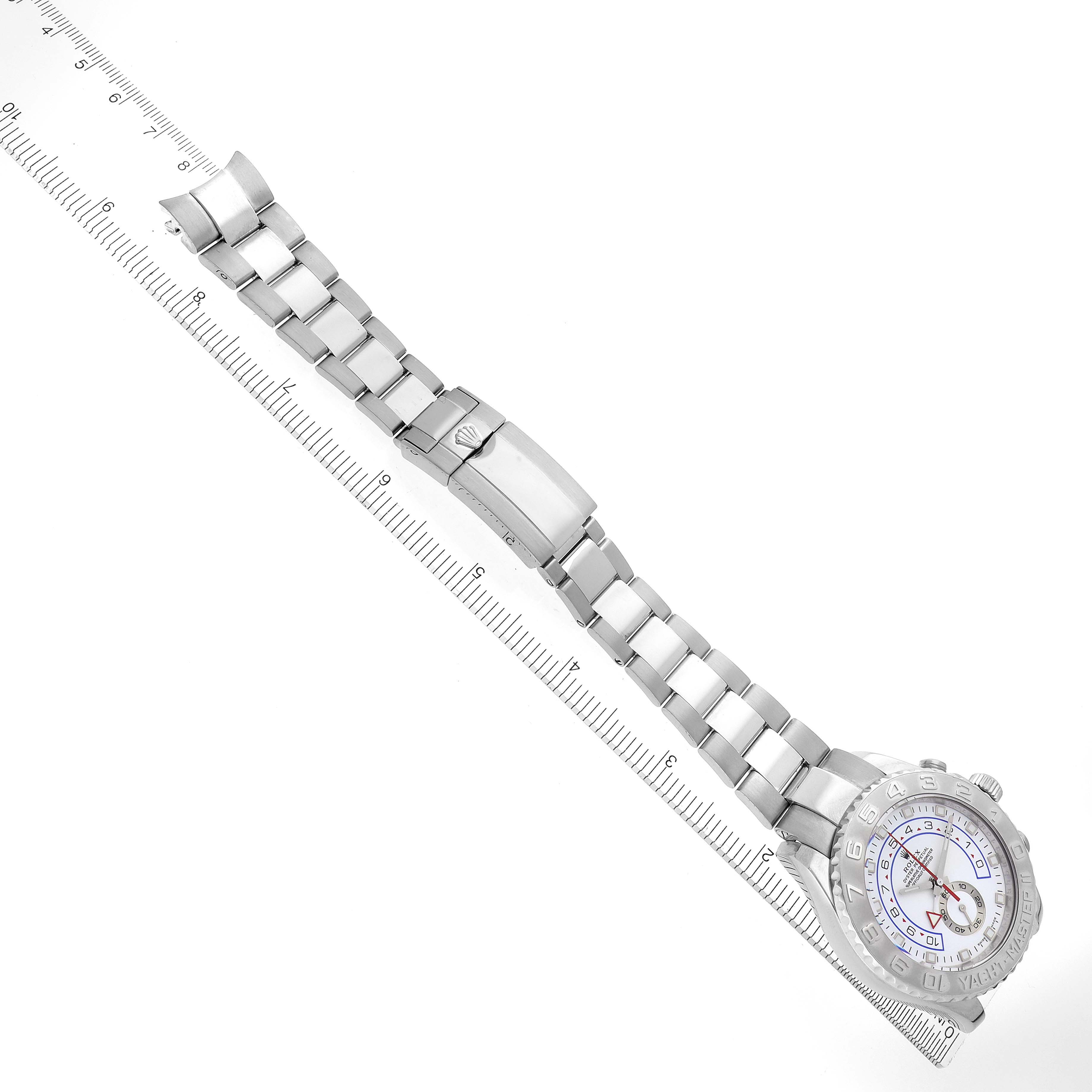 The Rolex Yacht-Master 116689 Men's Platinum White Dial watch is shown at a diagonal angle, displaying the full bracelet, clasp, and face alongside a ruler.