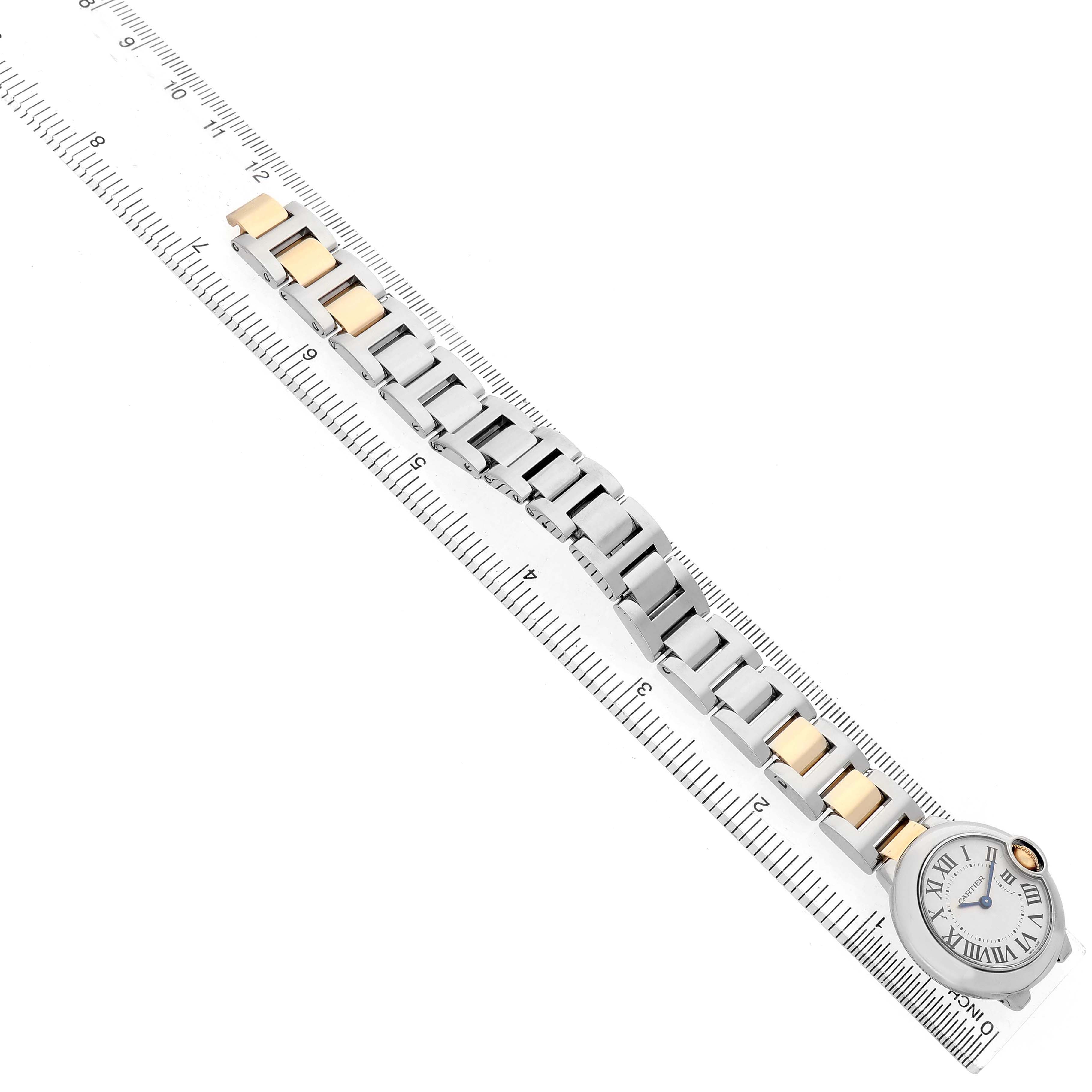 The Cartier Ballon Bleu W69007Z3 Women's Stainless Steel Silver Dial watch is displayed flat along a ruler, showing the full bracelet and face from a top-down angle.