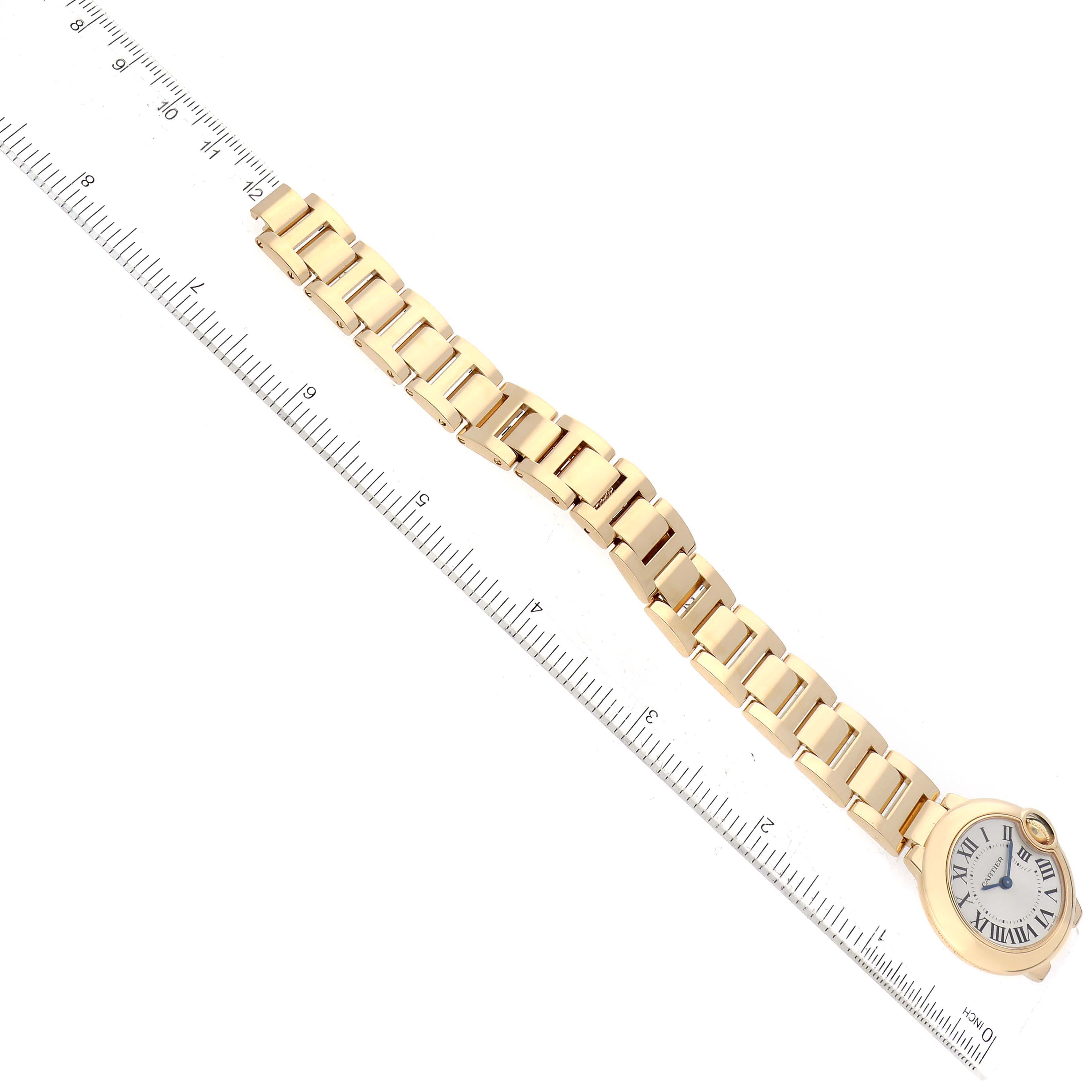 The image shows a top-down view of a Ballon Bleu model watch by Cartier, with the focus on its bracelet and face.