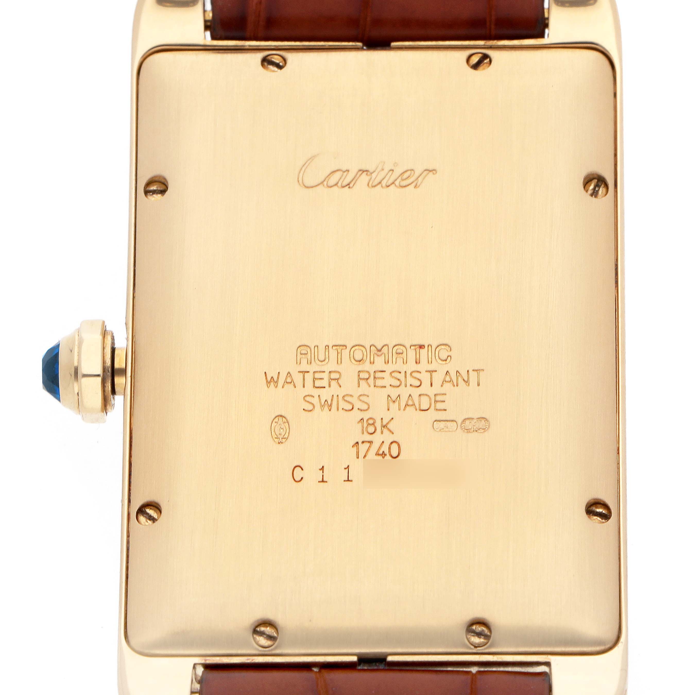 The image shows the back of a Cartier Tank Americaine W2603156 Men
s Yellow Gold Silver Dial watch, highlighting engravings and the crown with a blue cabochon.